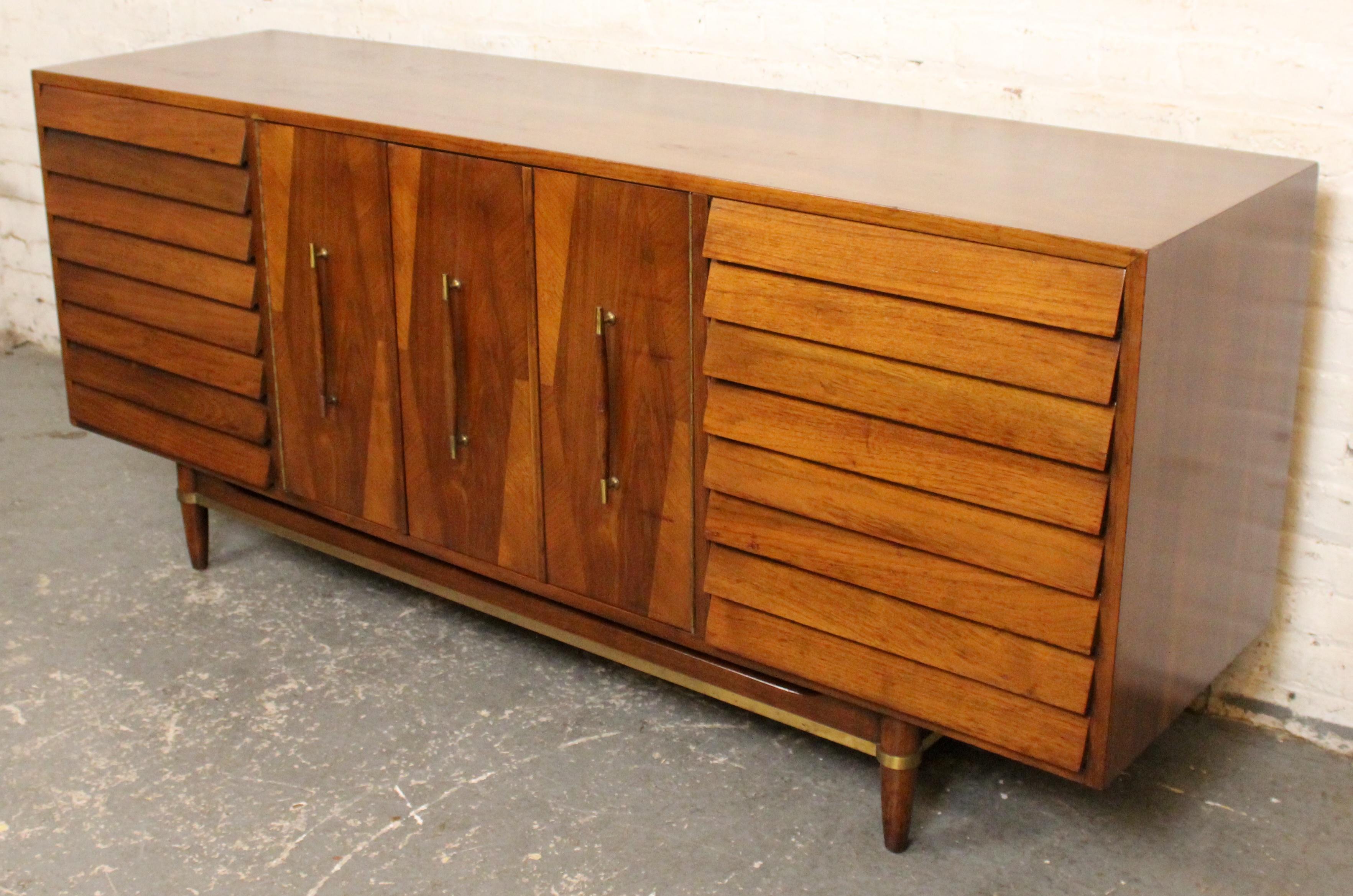 Merton Gershun designed sideboard for his celebrated ‘Dania’ line with American of Martinsville. Features clean mid-century lines, louvered drawers, signature walnut finish, and brass accents—an iconic example of Gershun’s blend of modern form and