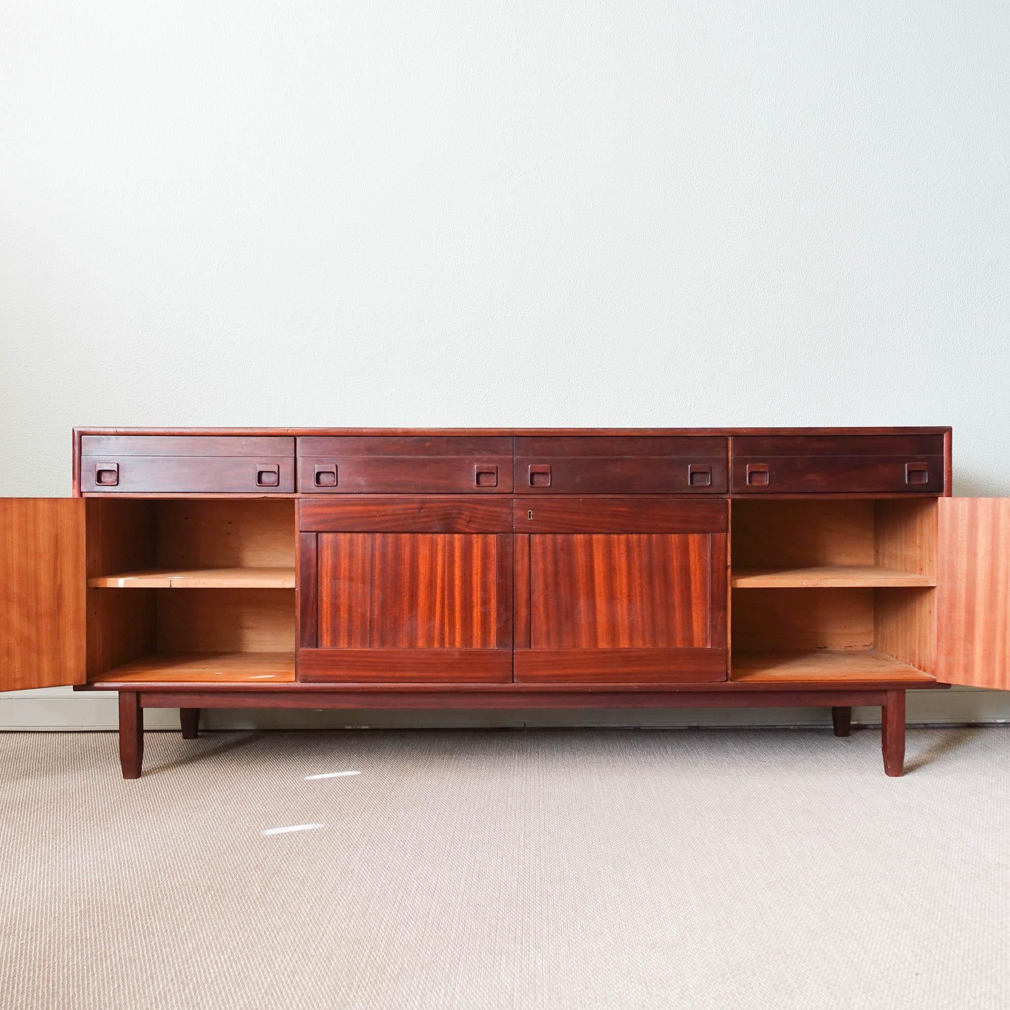 This sideboard was designed by José Espinho and produced by Olaio, in Portugal, during the 1970's. It is made of mutenye with square wooden handles. It features four drawers and four doors, that conceal storage space behind. In original condition.