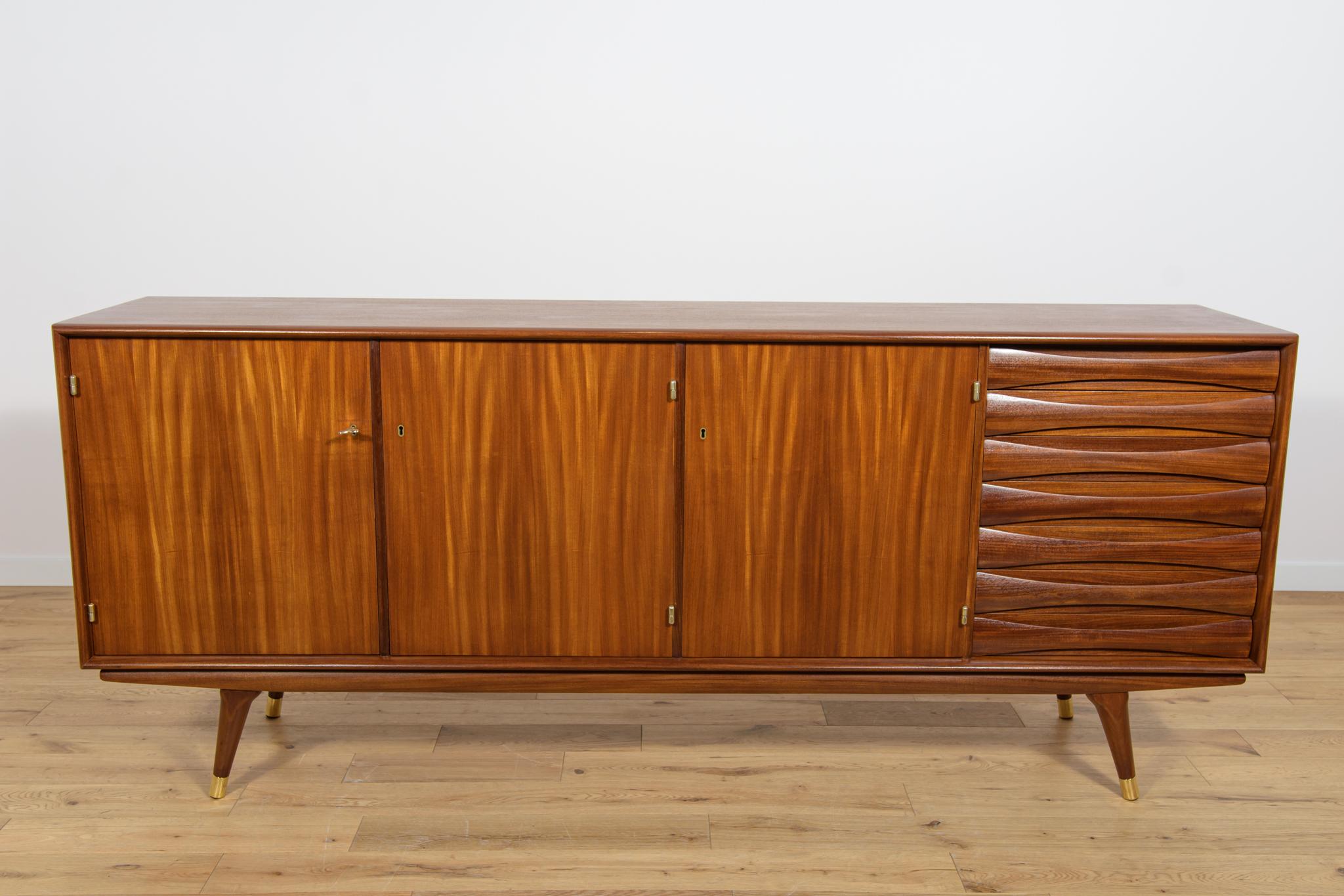 Das Sideboard aus Teakholz wurde in den 1960er Jahren von Sven Andersen für seine norwegische Möbelfabrik Stavanger entworfen. Die Möbel wurden fachgerecht restauriert, indem alte Anstriche entfernt, mit Eichenbeize gebeizt und mit hochwertigem