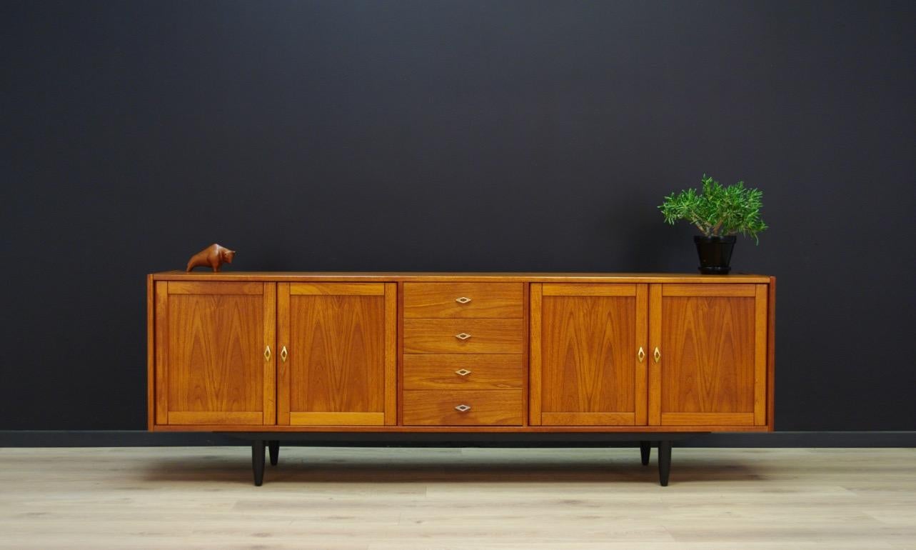 Rare sideboard from the 1960s-1970s, Minimalist form, Danish design. In the central section, four practical drawers, in the side sections, roomy space with a shelf behind the doors. The whole veneered with teak. Preserved in good condition (small