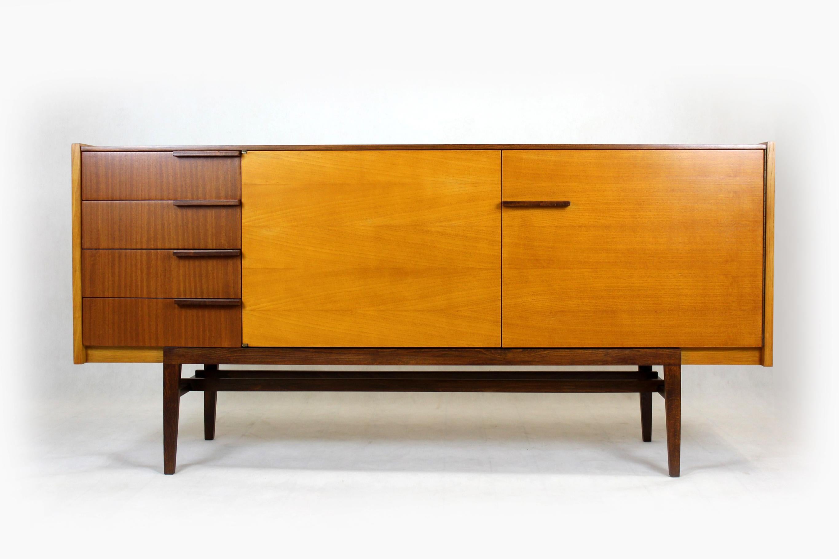 Mid-century sideboard, produced by UP Bucovice in former Czechoslovakia in the 1960s.
Made of two types of wood - ash and mahogany, it features four drawers and three shelves.
The sideboard has been completely restored, lacquered, satin finish.
 