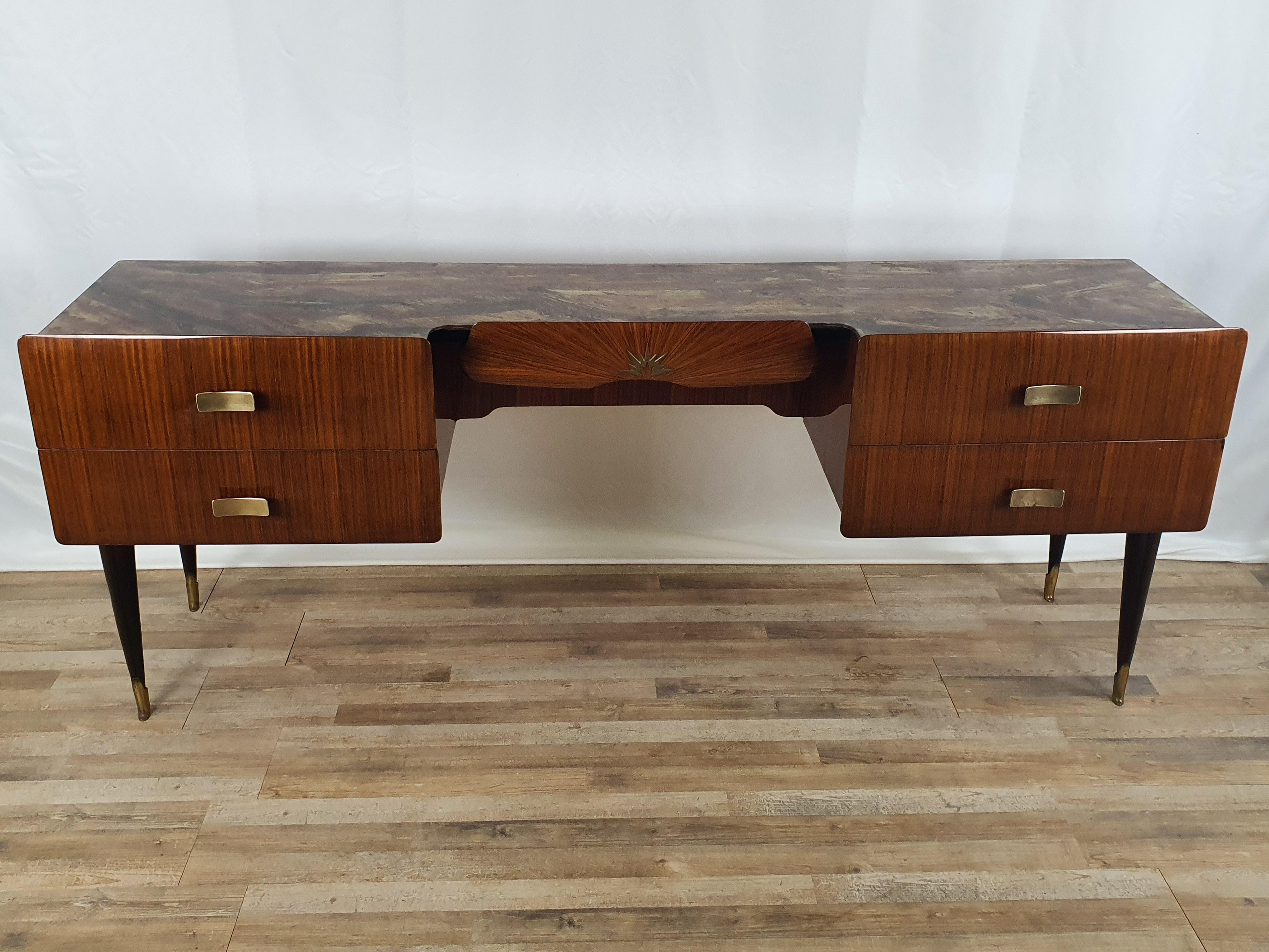 Chic midcentury Italian chest of drawers circa 1950 in mahogany with brass trim and handles.

Note the glass placed on the main floor, original of the period, as it gives refinement and particularity to the piece of furniture to make it suitable