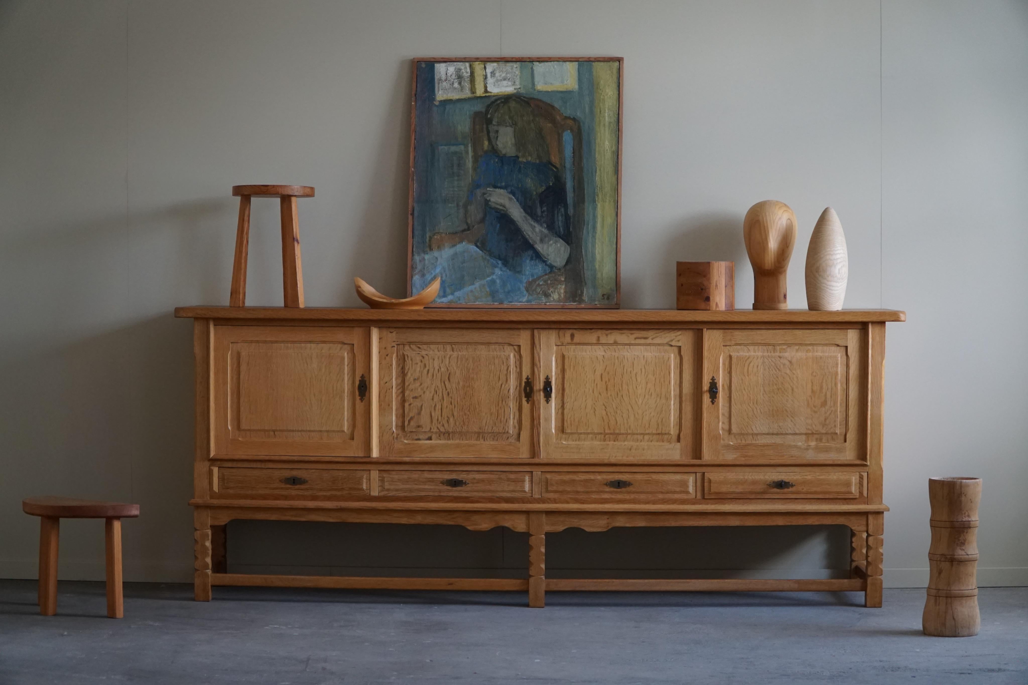 A large rectangular classic sideboard / cabinet in oak with plenty of storage and a refined carved front design. Made by a Danish cabinetmaker in the 1960s. 
This piece is in a good vintage condition.

This amazing brutalist sideboard will