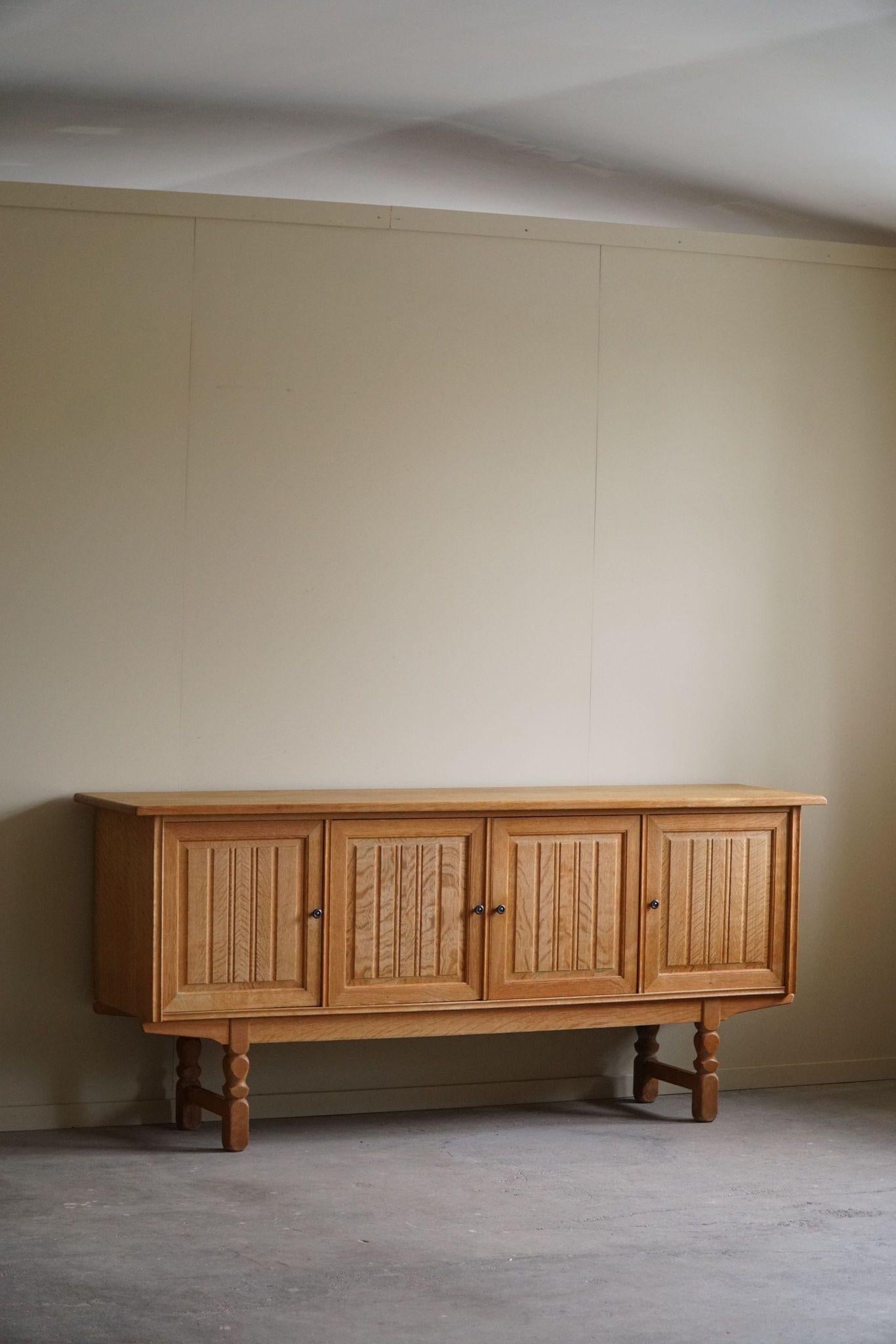 Ein klassisches rechteckiges Sideboard / Schrank in Eiche mit viel Stauraum und einem raffinierten geschnitzten Frontdesign. Hergestellt von einem dänischen Möbelschreiner in den 1960er Jahren.
Dieses Stück ist in einem guten Vintage-Zustand.