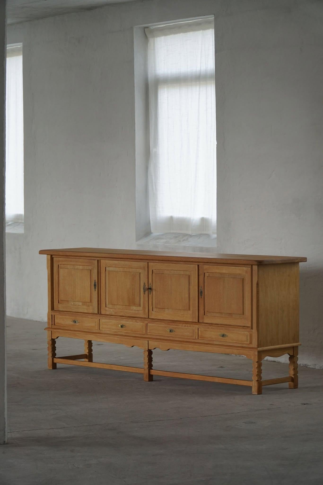 Una grande credenza/armadio classico rettangolare in quercia con un ampio spazio di archiviazione e un raffinato design intagliato sul davanti. Realizzato da un ebanista danese negli anni '1960. 
Questo pezzo è in buone condizioni vintage.

Questa