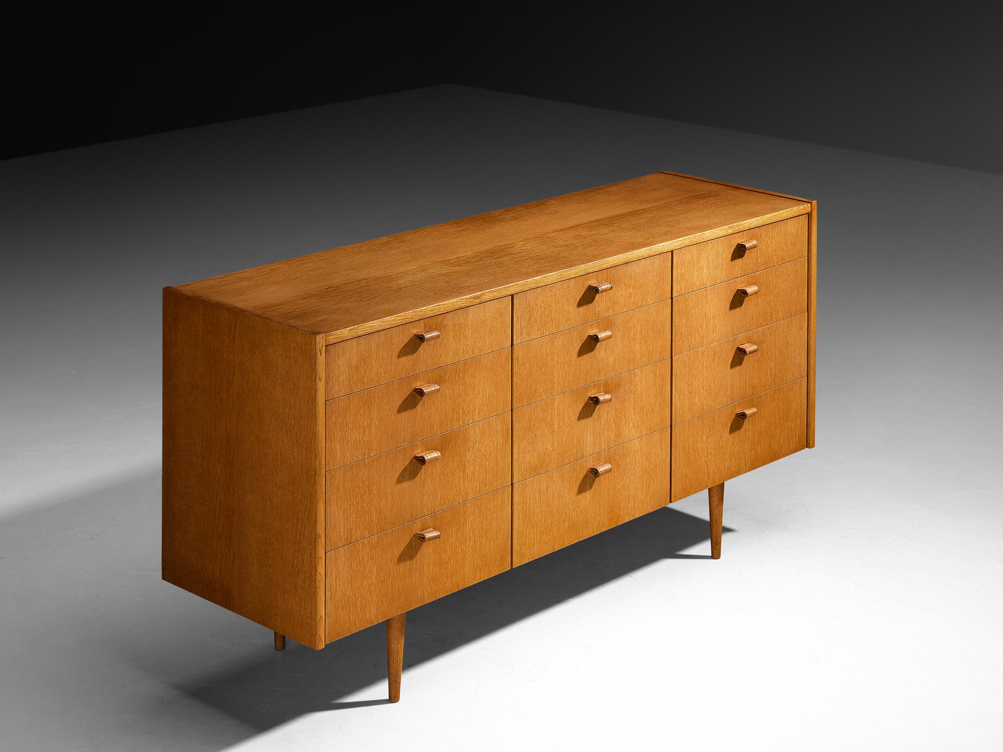 Sideboard, oak, leather, Europe, 1950s

This exquisite sideboard, crafted in the 1950s, embodies the timeless elegance of mid-century design. Constructed from warm oak, its clean lines and balanced proportions highlight the natural beauty of the