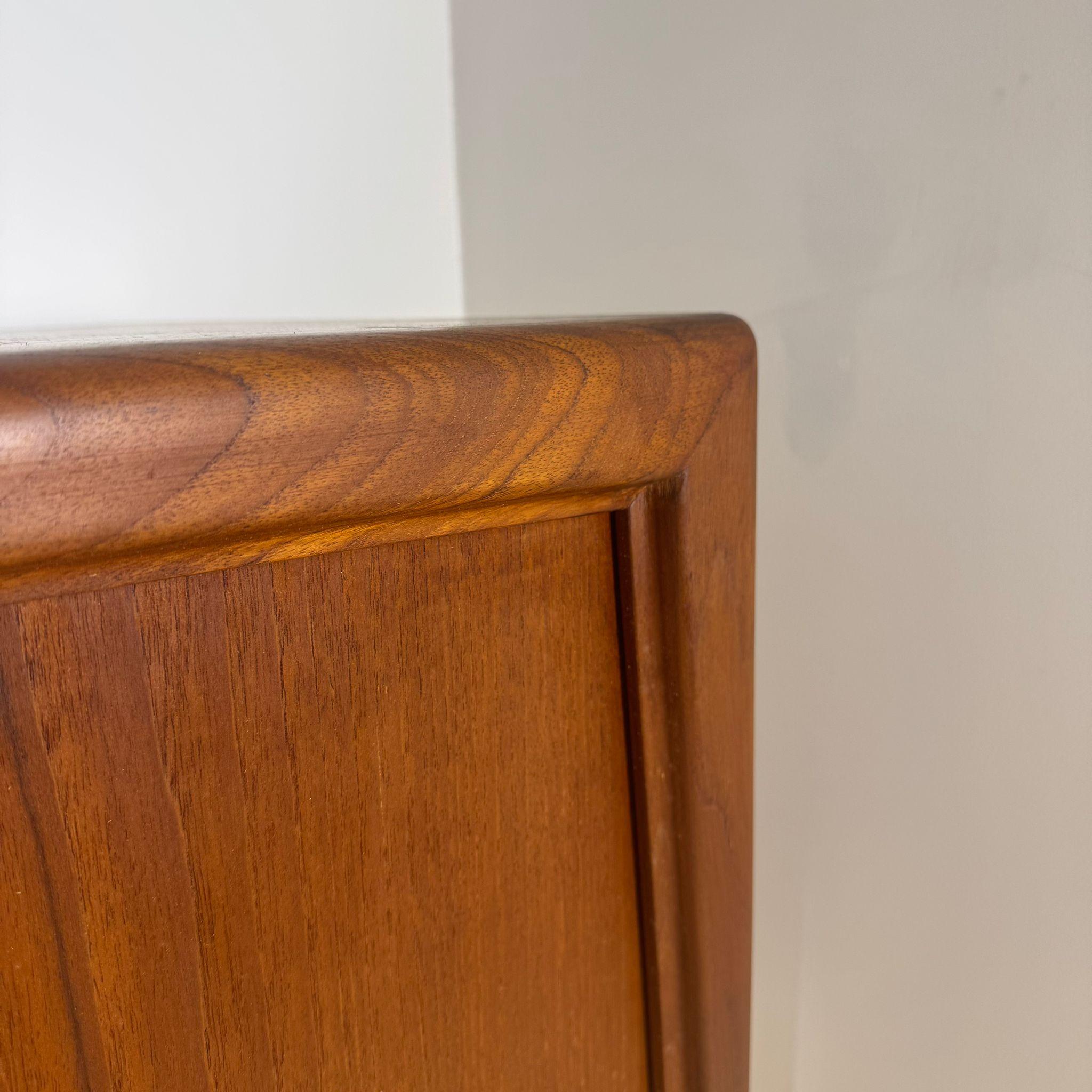 Scopri il fascino autentico del design scandinavo con questa straordinaria credenza vintage danese degli anni '60. Firmata da Axel Christensen per ACO Mobler, è realizzata in teak massello, materiale che invecchia magnificamente nel tempo. Die