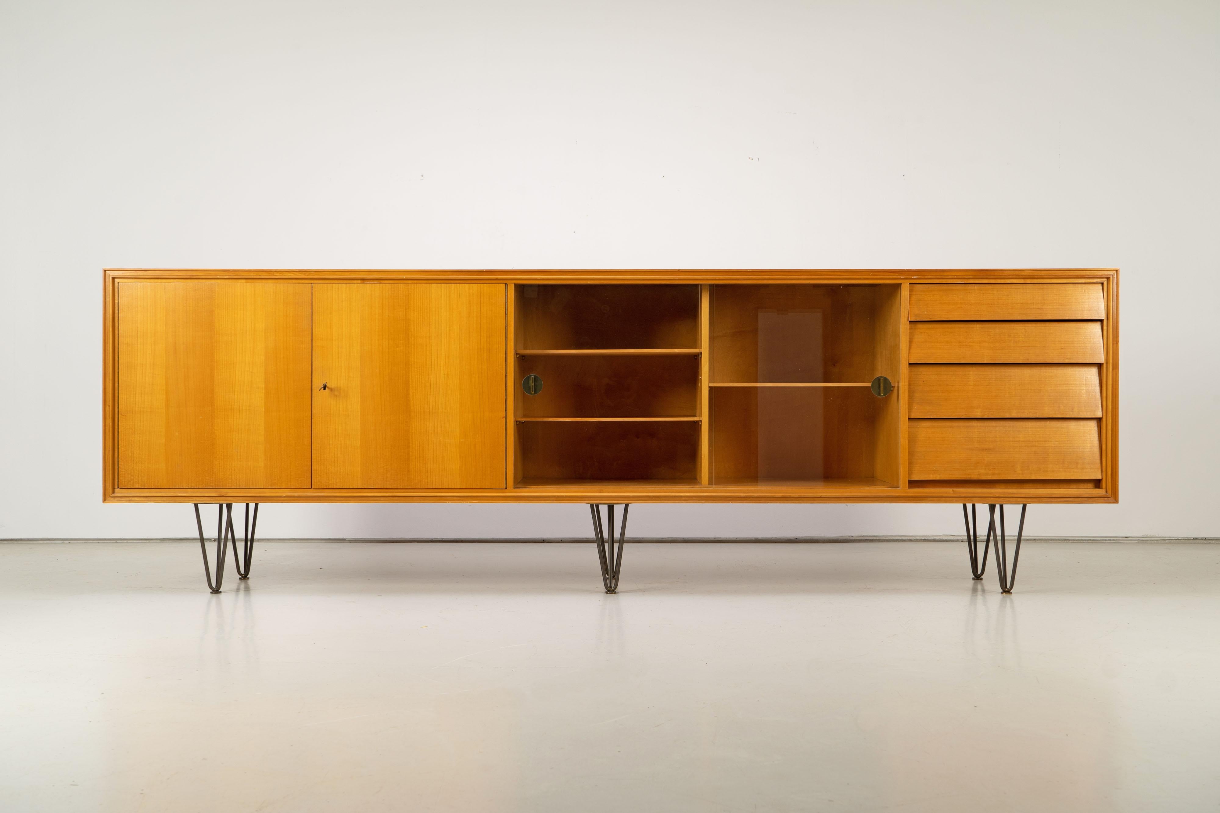 Great sideboard in the style of Alfred Altherr from the 1950s. The furniture is in excellent orriginal condition with original hairpin feet and handles made of brass. The surfaces are veneered with ash wood.