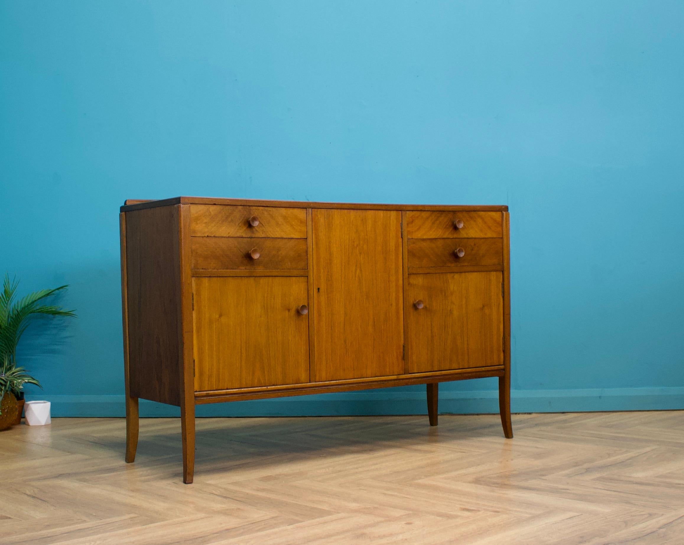 A mid century walnut sideboard - in the manner of Gordon Russell

Featuring three cupboards - with shelves (some are later additions) and four drawers