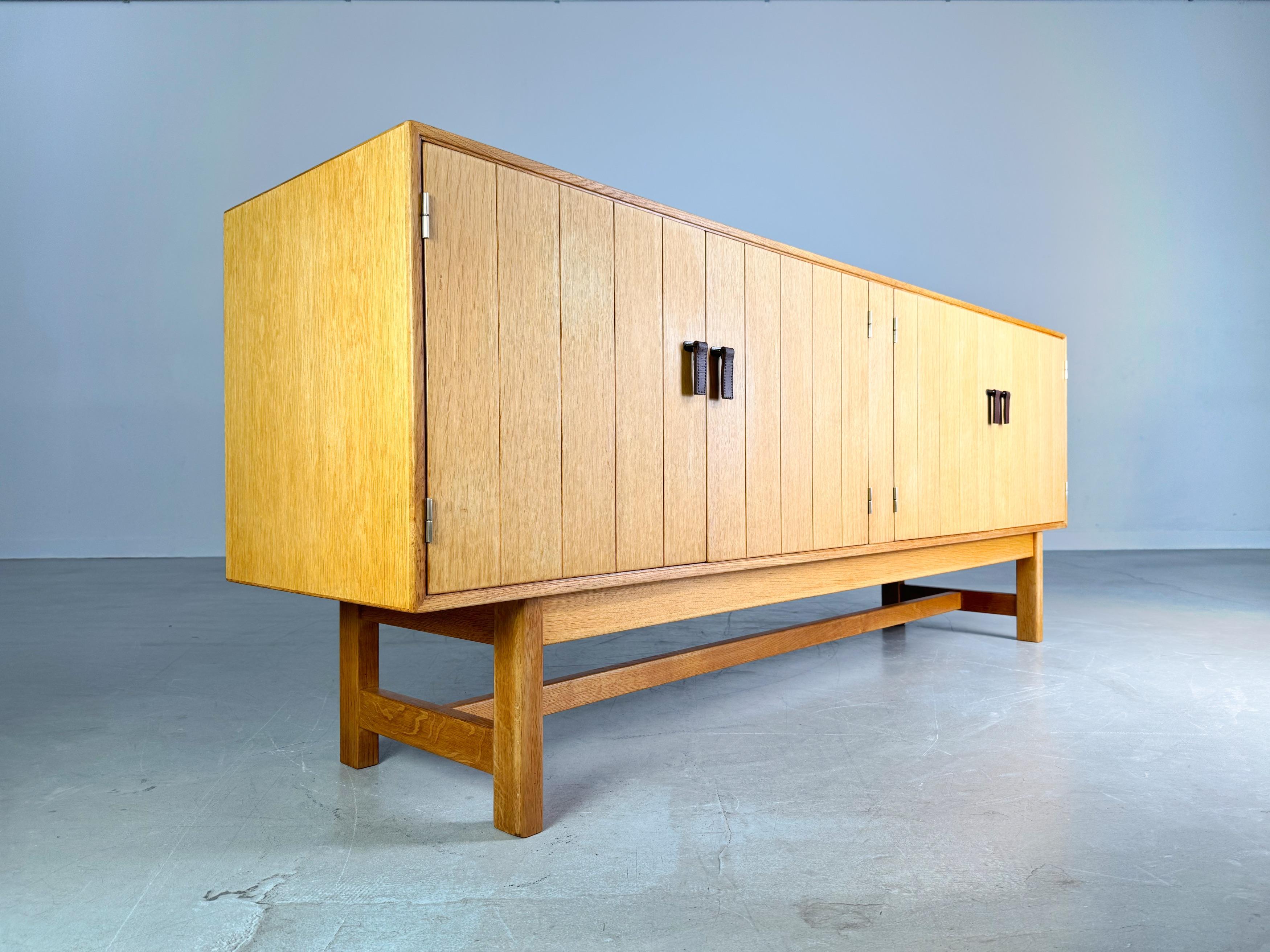 We are offering for sale a beautiful midcentury sideboard by KP Mobler from the 1960s. The design is by Kurt Ostervig and is characterized by its unique door handles and a very minimalist shape. The sideboard has 4 doors, behind three of which there