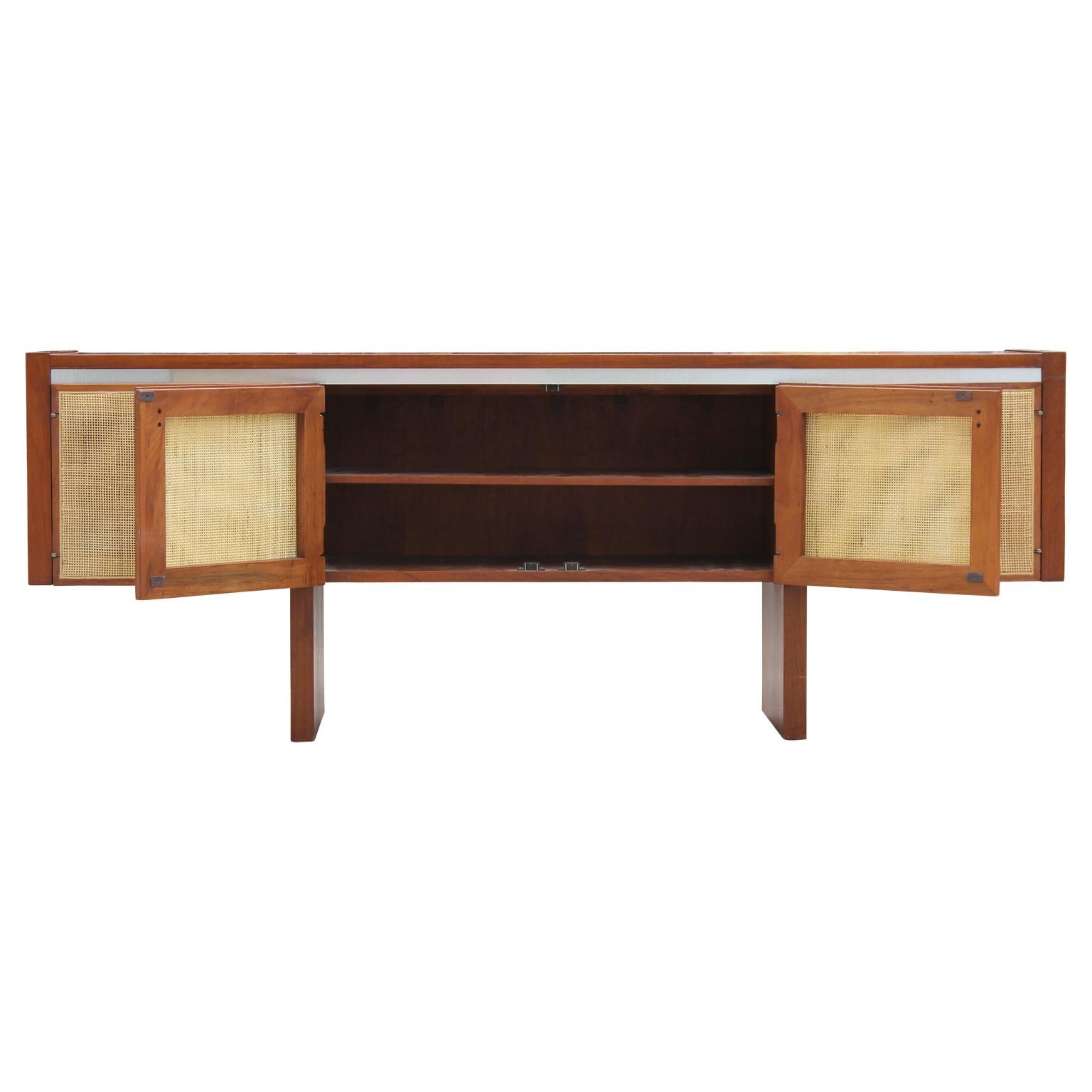 Striking caned credenza attributed to Edward Wormley for Dunbar. It has four doors that are caned with shelving inside.