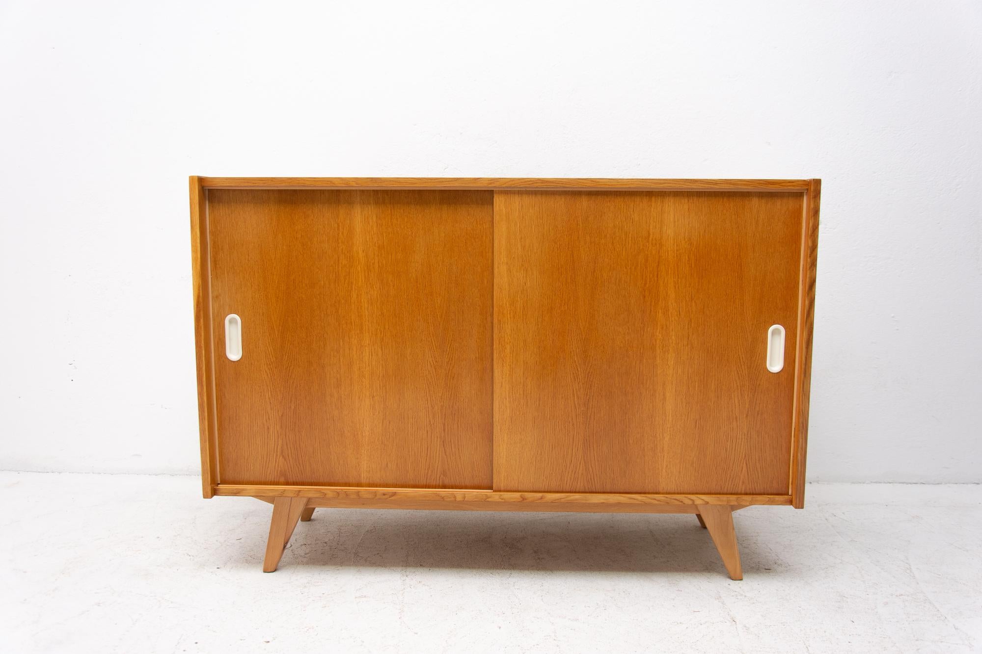 Midcentury sideboard with sliding doors and one long shelf inside, designed by Jirí Jiroutek in the 1960s. It´s made of oak wood. In excellent condition, fully refurbished.