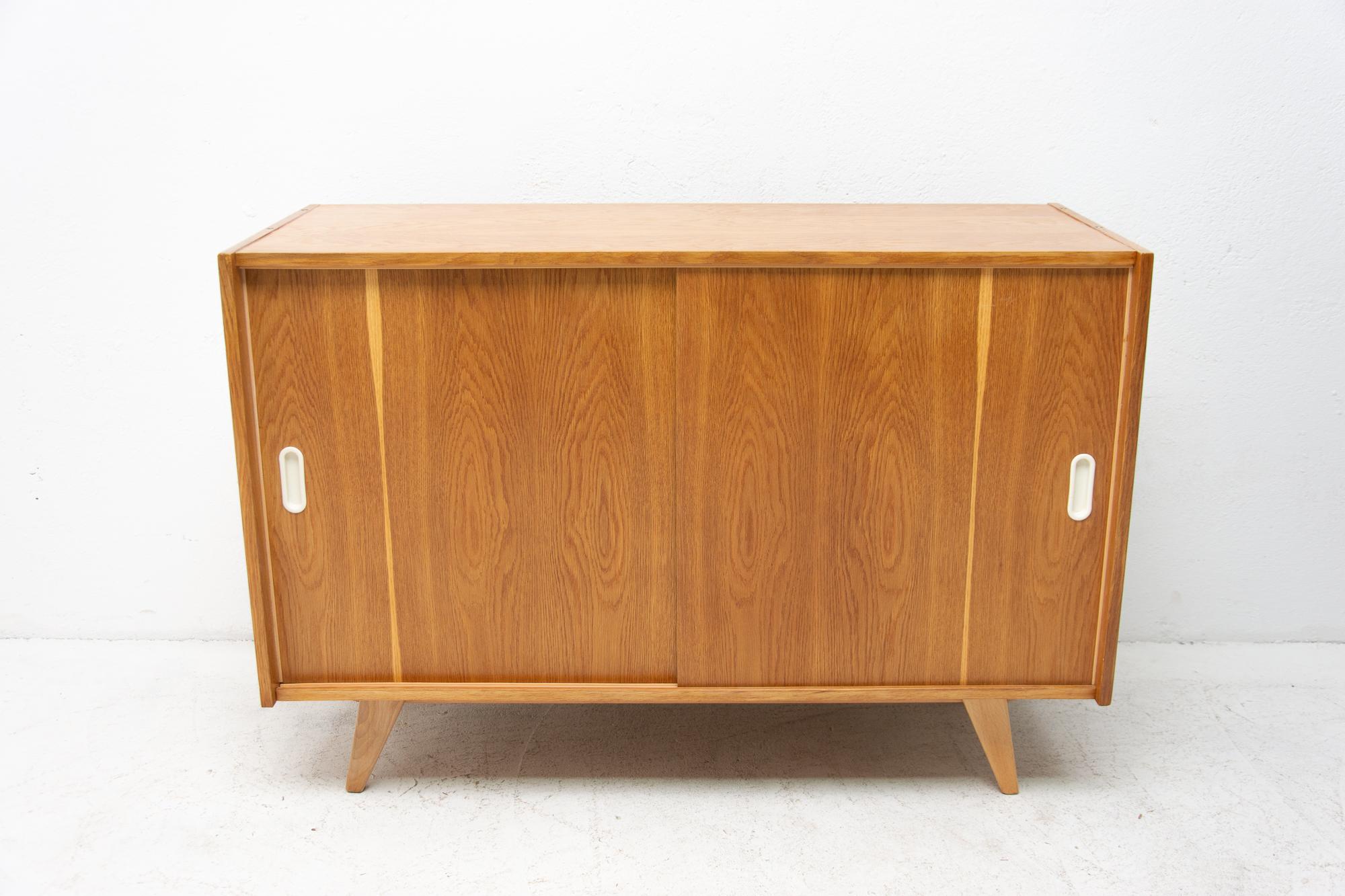 Midcentury sideboard with sliding doors and one long shelf inside, designed by Jirí Jiroutek in the 1960s. It´s made of oakwood. In excellent condition, fully refurbished.