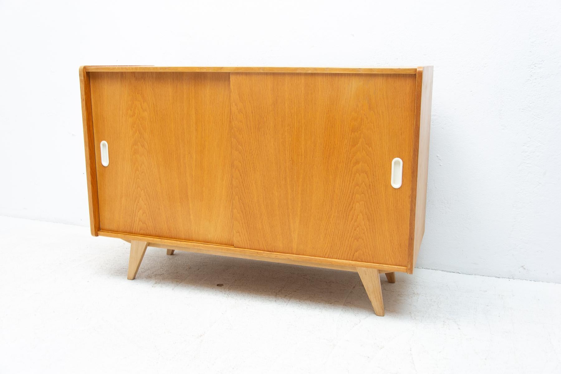 Mid-Century-Sideboard mit Schiebetüren und einem langen Regal im Inneren, entworfen von Jir Jiroutek in den 1960er Jahren. Er ist aus Eichenholz und Sperrholz gefertigt. In sehr gutem Zustand, nur ein kleiner Fleck auf der Oberseite.

Maße: Höhe: