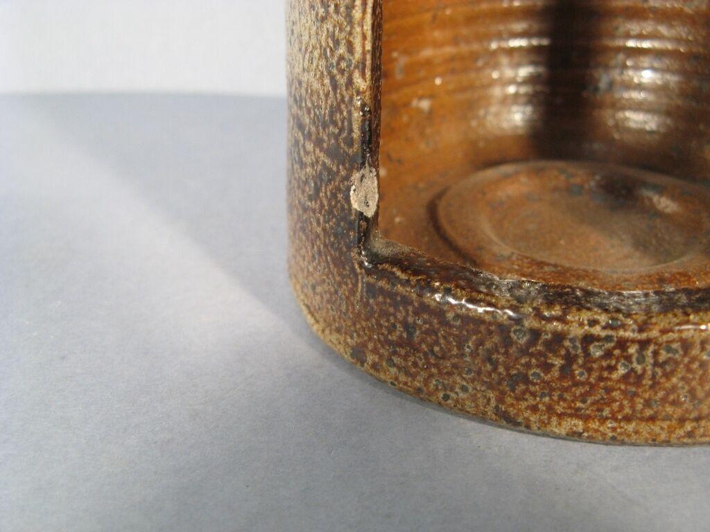 This captivating mid-century signed anthropomorphic stoneware tea light holder adds a touch of unique charm and vintage character to any home décor. The stylized head shape and the rustic stoneware construction make it a delightful addition to any