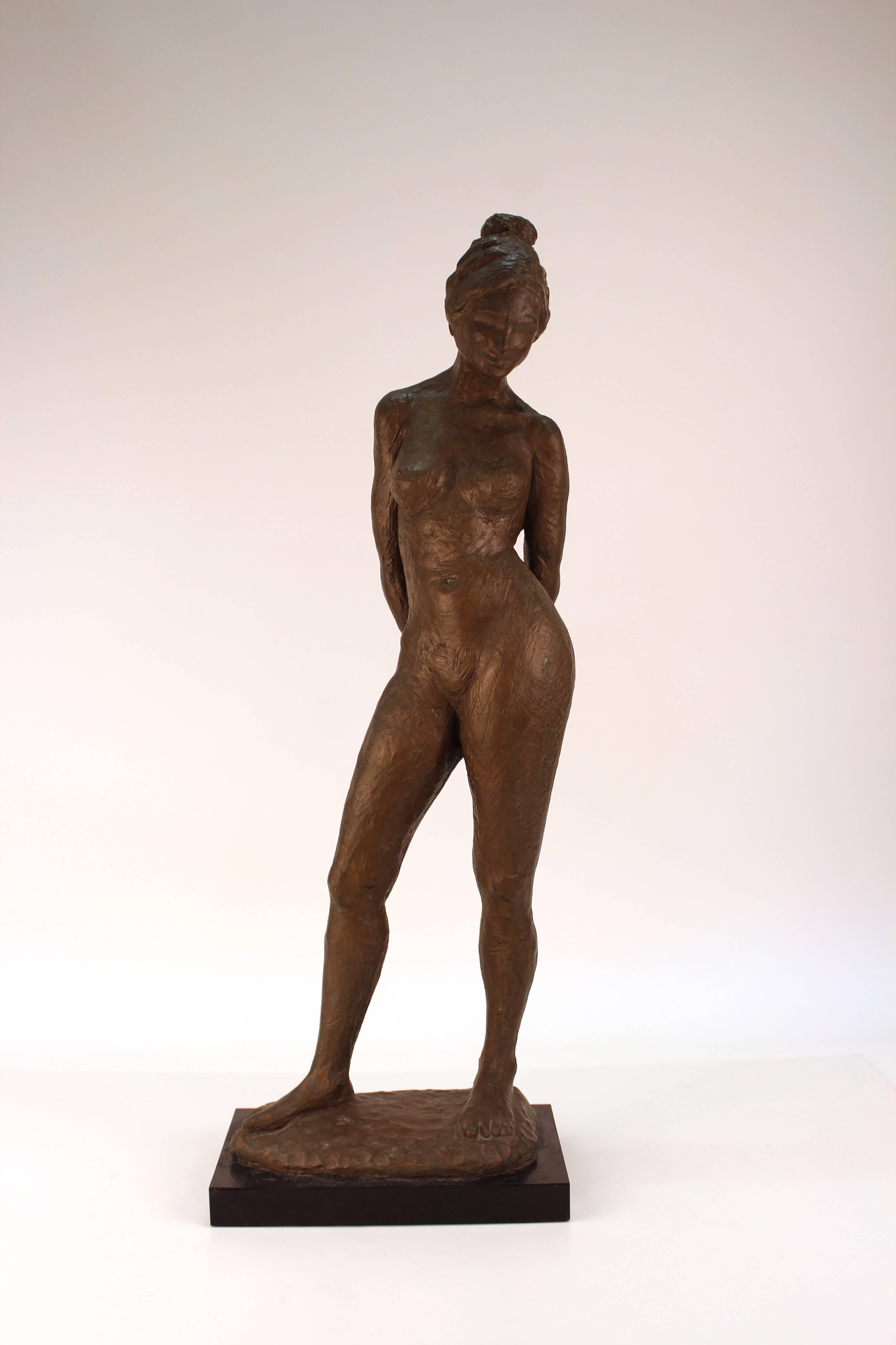 A Mid-Century Modern ceramic sculpture of a nude woman, signed [Herio-Rich '75] on the base. The piece is painted olive green and comes with a black resin base. The piece is in good vintage condition.