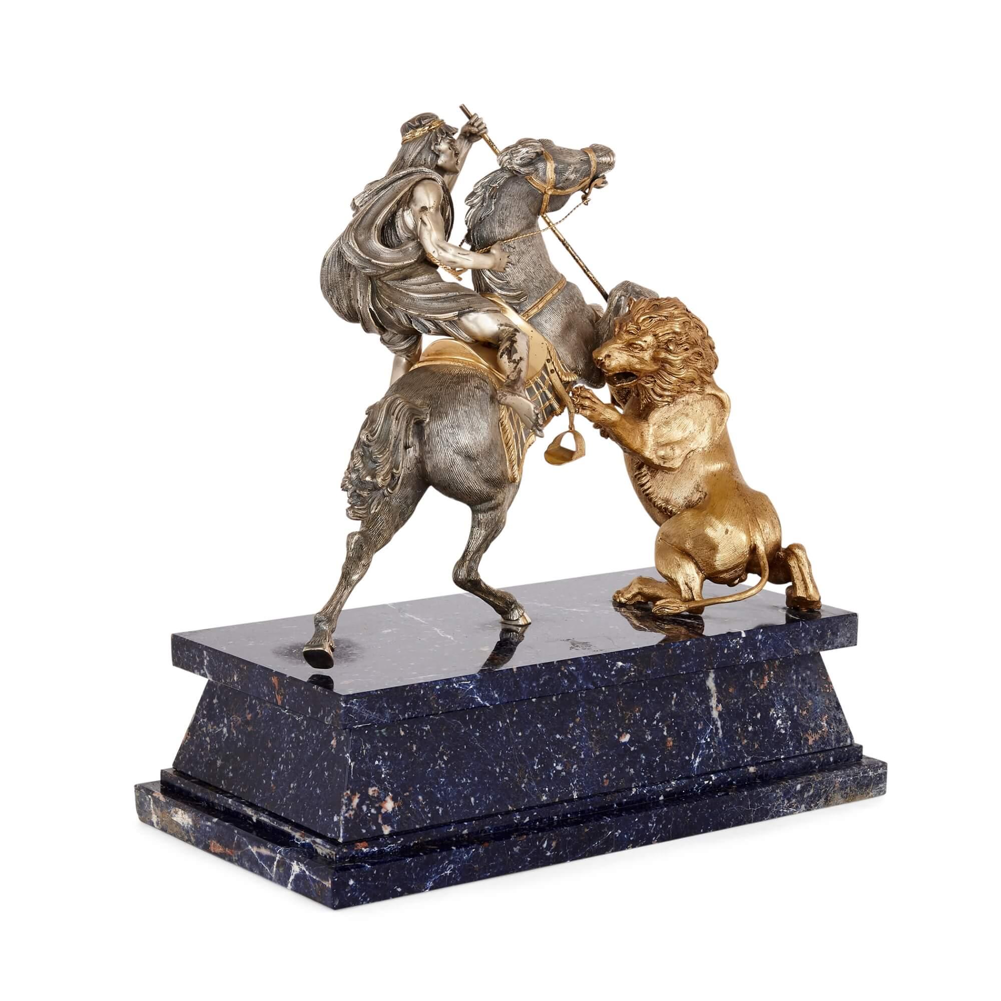 Mid-century silver and silver-gilt animalier sculpture.
Italian, c. 1970s
Dimensions: Height 33cm, width 32cm, depth 17cm

This dynamic silver and silt-gilt sculptural group depicts a naturalistic horse and its rider battling a lion. The lion