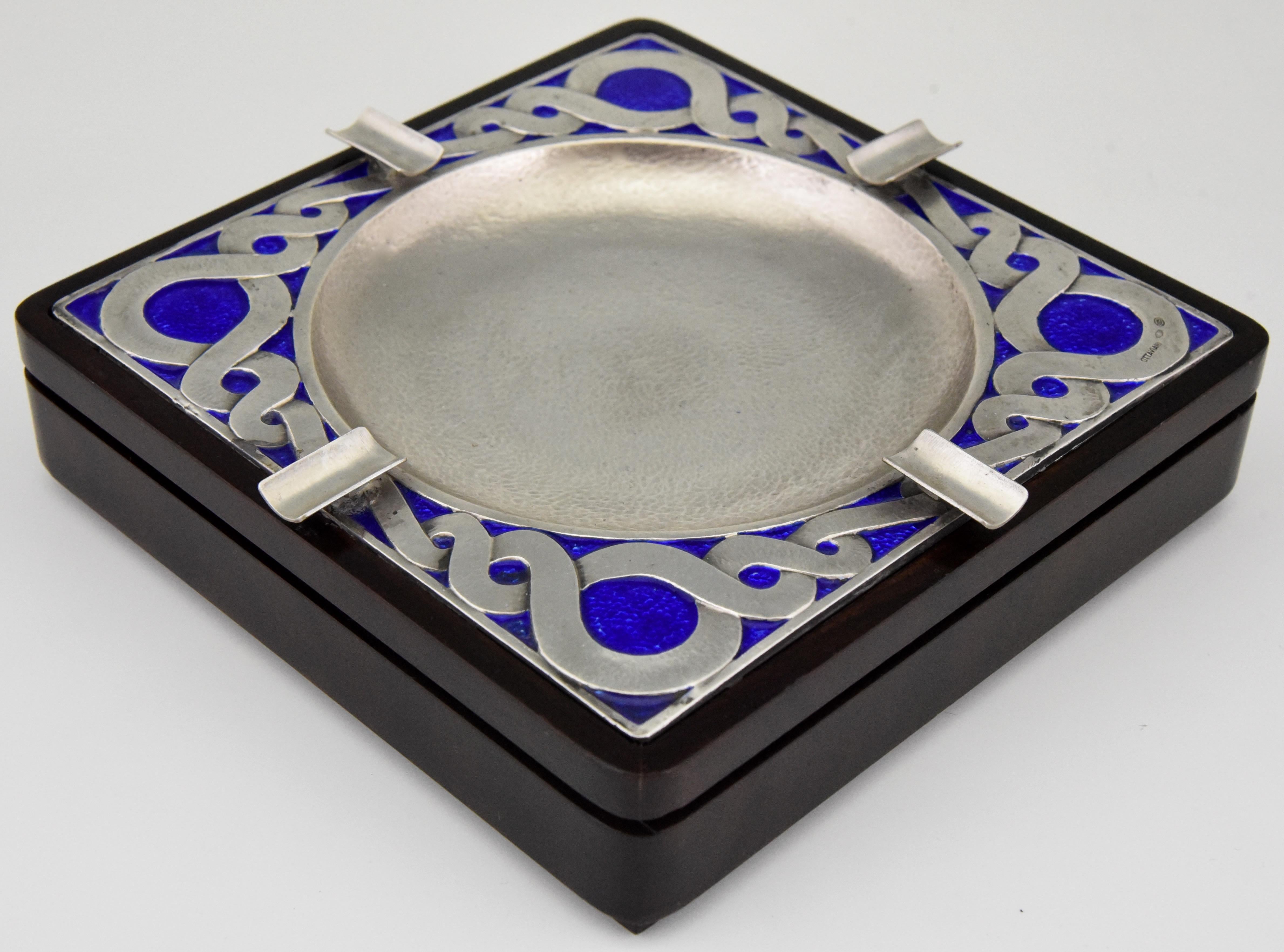 Stylish large midcentury large hammered silver table ashtray with blue enamel and wooden base.
By the Italian silversmith Otttaviani, circa 1970. 

Ottaviani (1945) is a jewelry and silver firm located in the small seaside town of Recanati,