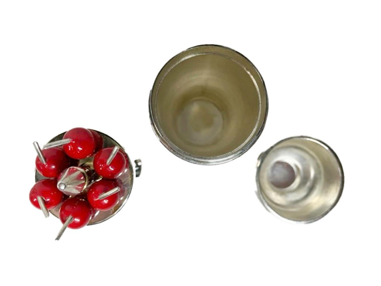 Vintage silver plate jigger and cocktail pick set, private labeled for Neiman Marcus and attributed to P.H. Vogel & Co of Birmingham, England. A set of six forked cocktail picks with red cherry tops in a stand fitted into a covered jigger in the