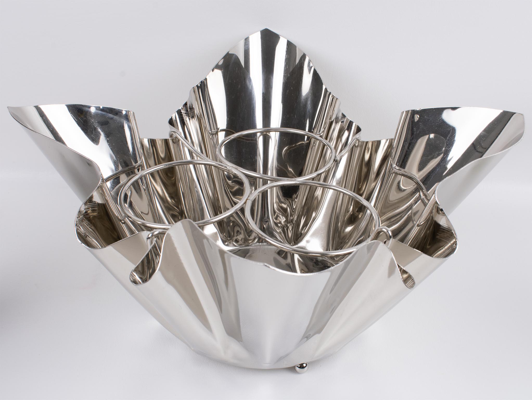 Este elegante enfriador de vino o cubitera de champán de mediados de siglo se fabricó en Francia hacia 1960. Este portabotellas ultra-chic tiene una caprichosa forma de pañuelo. La pieza de bar tiene capacidad para tres botellas. Willy Guhl también