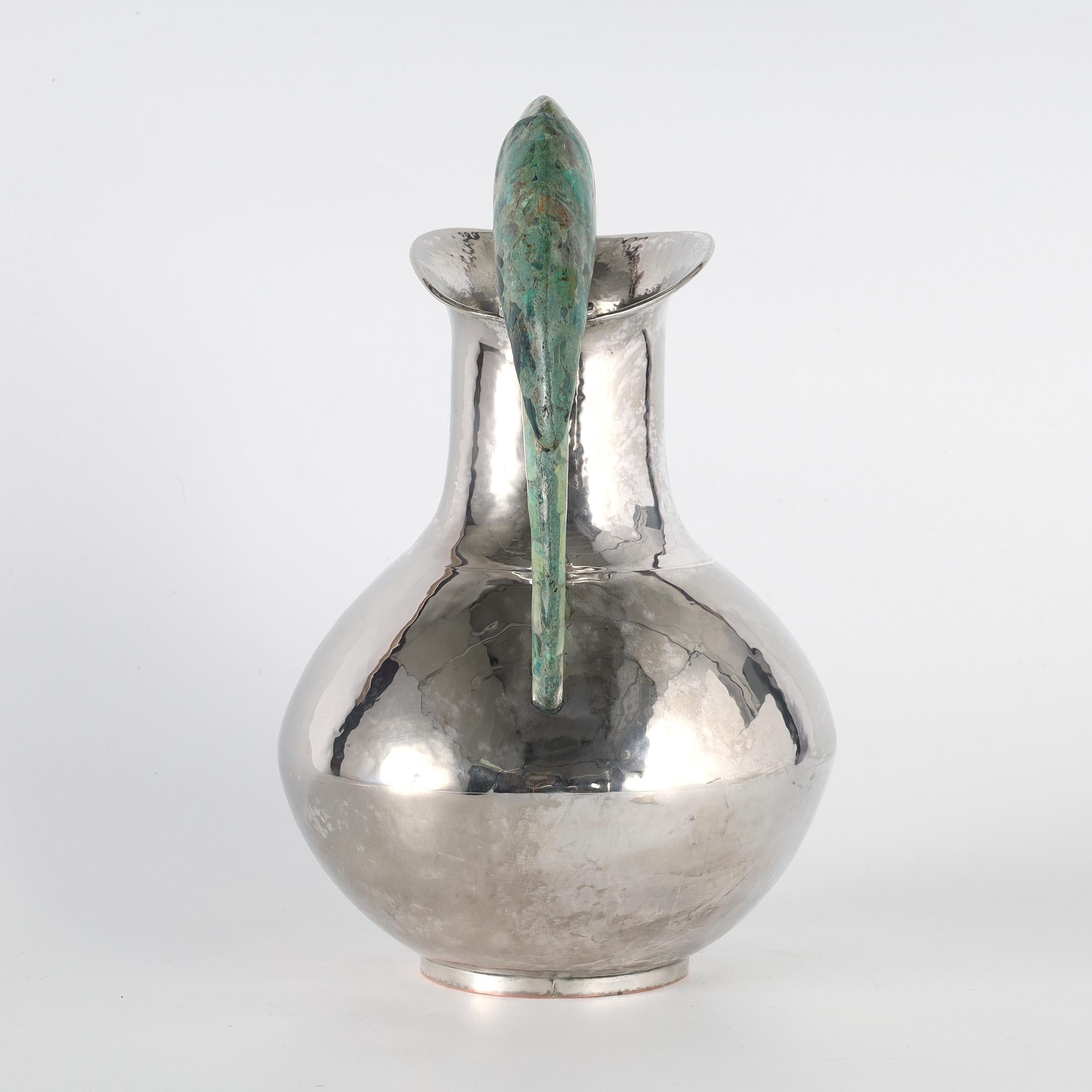 Standout vintage pitcher handcrafted in silver plate over hammered copper in modern form featuring a stone clad parrot as a handle. Stamped on the bottom Made in Mexico. 