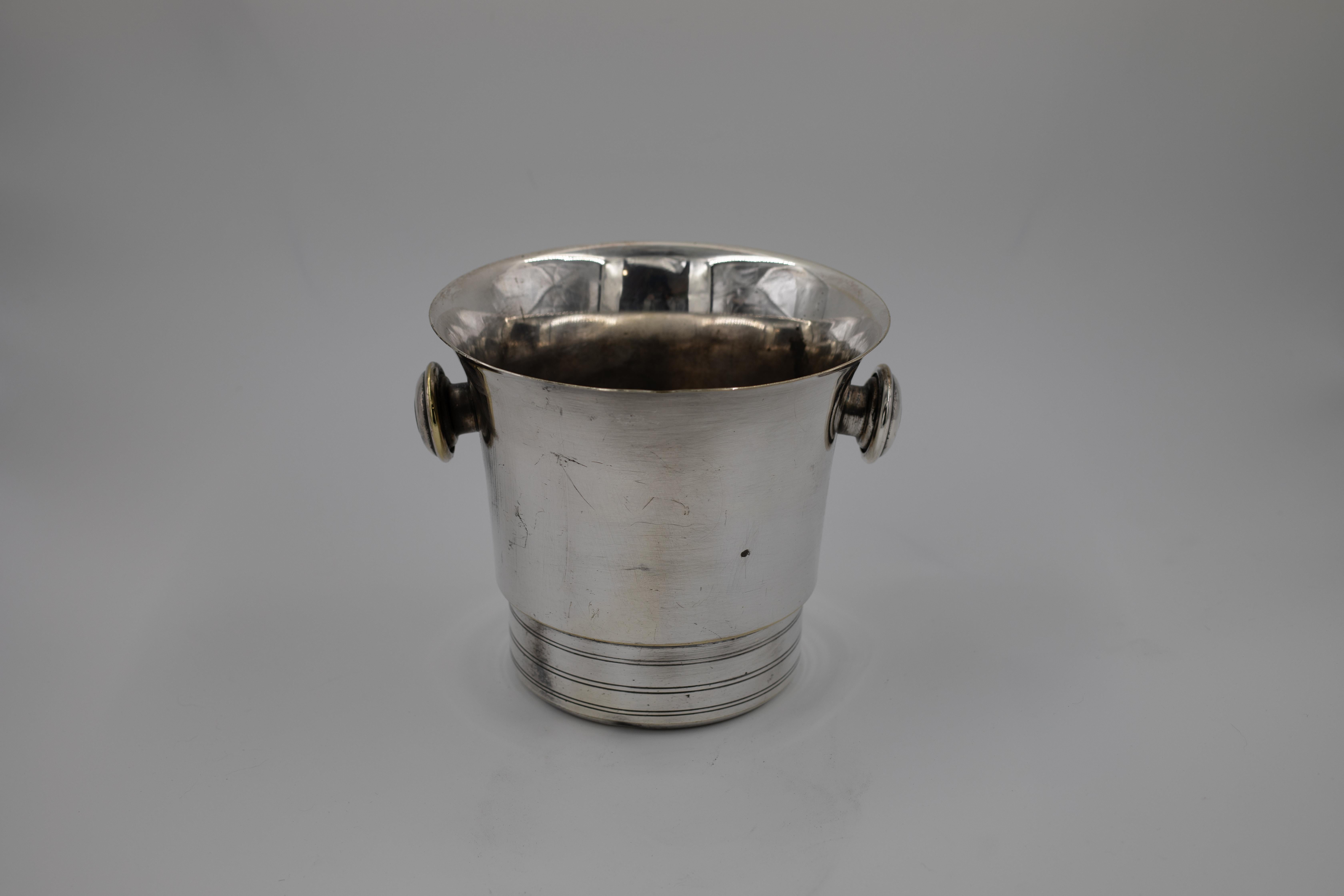 Un beau seau à champagne en métal argenté du milieu du siècle, aux lignes pures et discrètes et aux proportions classiques de la vaisselle de bar. La glacière a un bord légèrement évasé, de simples poignées latérales rondes et une base subtilement