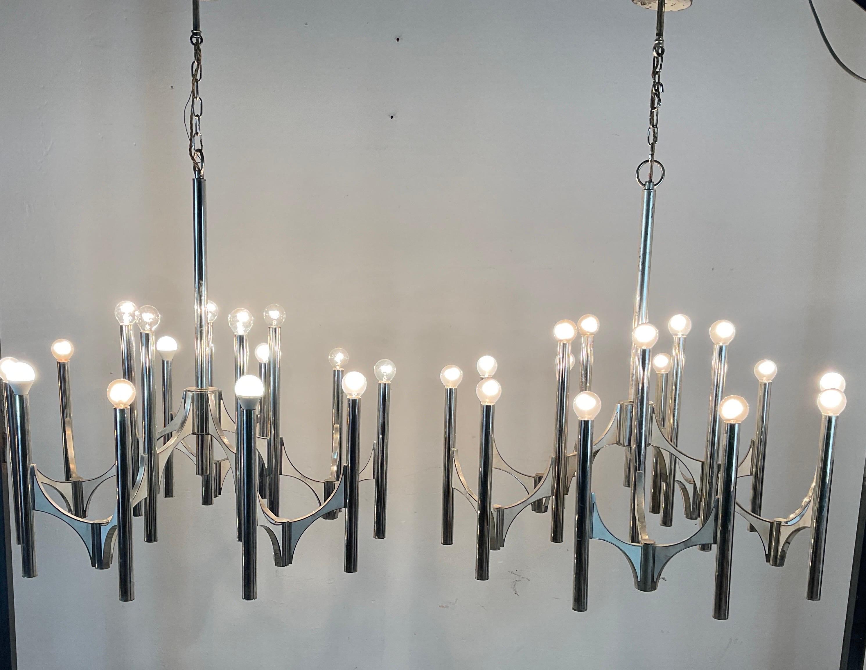Pair of modernist chandeliers from the 60s, designed by Gaetano Sciolari for Lightoiler, Italy. Made from silver plated brass. The chandelier has 5 arms and offers fifteen light sources. A stunning combination of silvered vertical tubes and