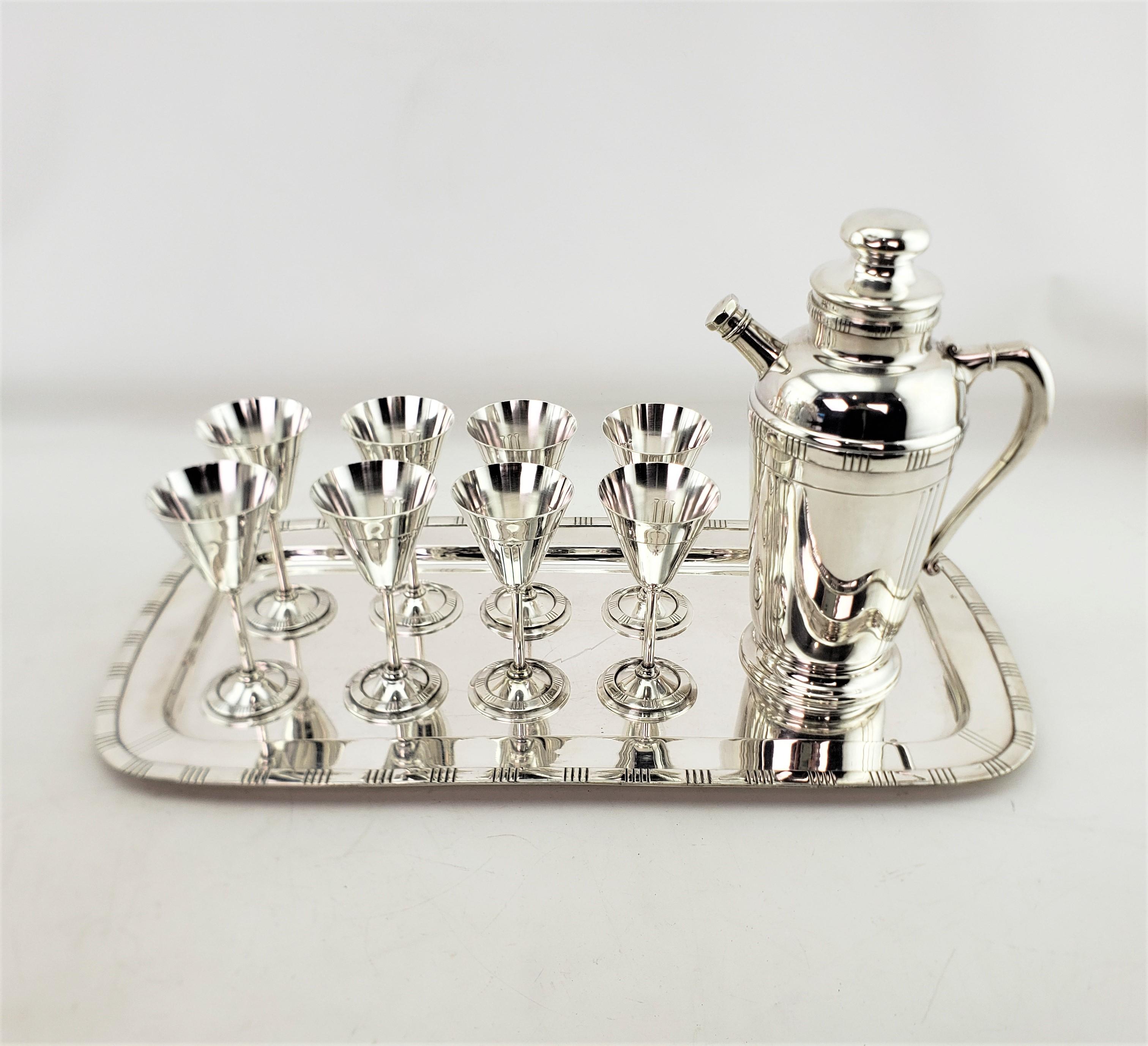 This vintage cocktail set was made by the Bernard Rice's & Sons of the United States and dates to approximately 1965 and done in their Patricia pattern. The set is composed of silver plate and consists of eight stemmed glasses, and shaker pitcher