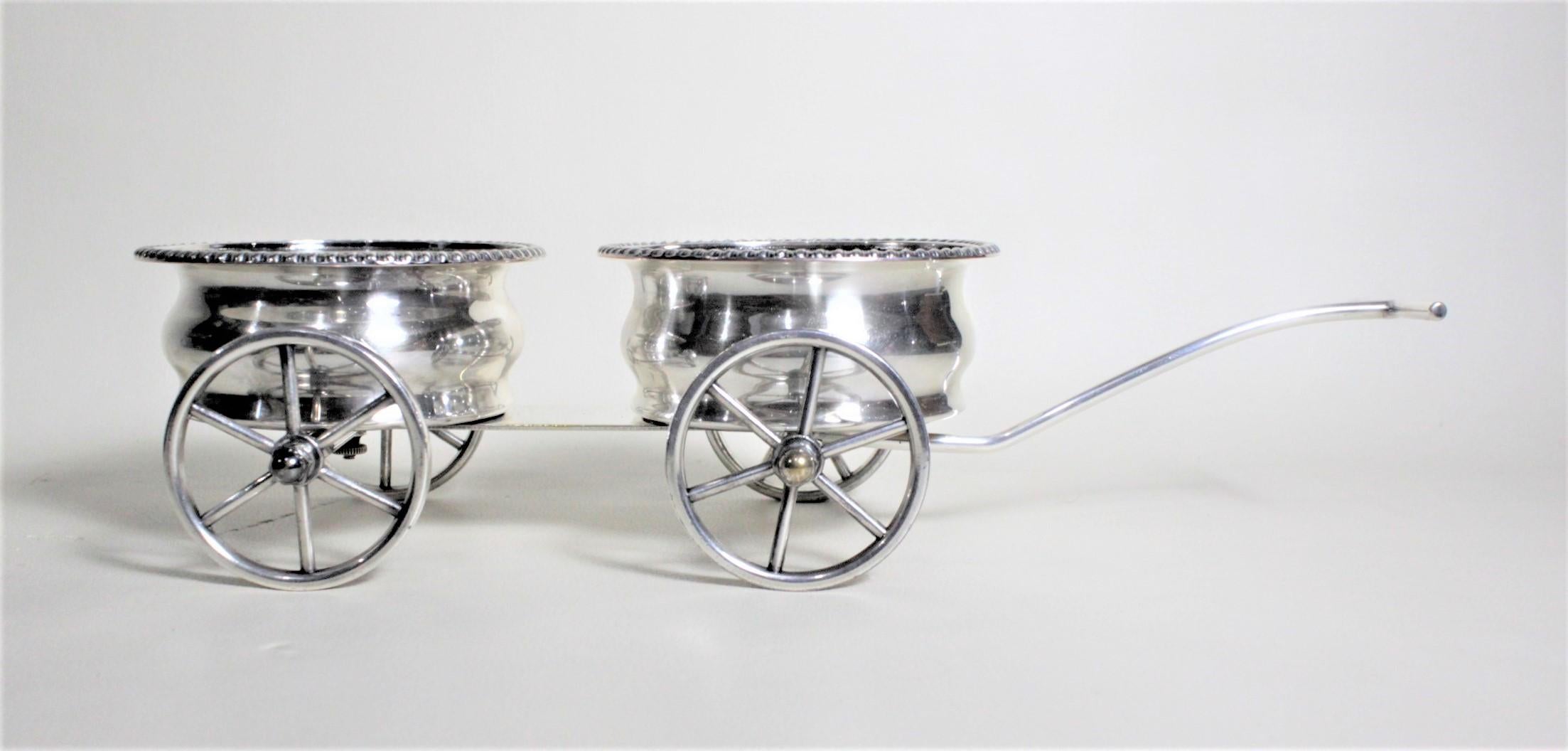 This silver plated figural wagon was made in England in circa 1965 in the style of a much earlier Victorian period. The wagon is solid cast brass and considerably sturdy and has freely turning spoked wheels and the front two pivot from side to side