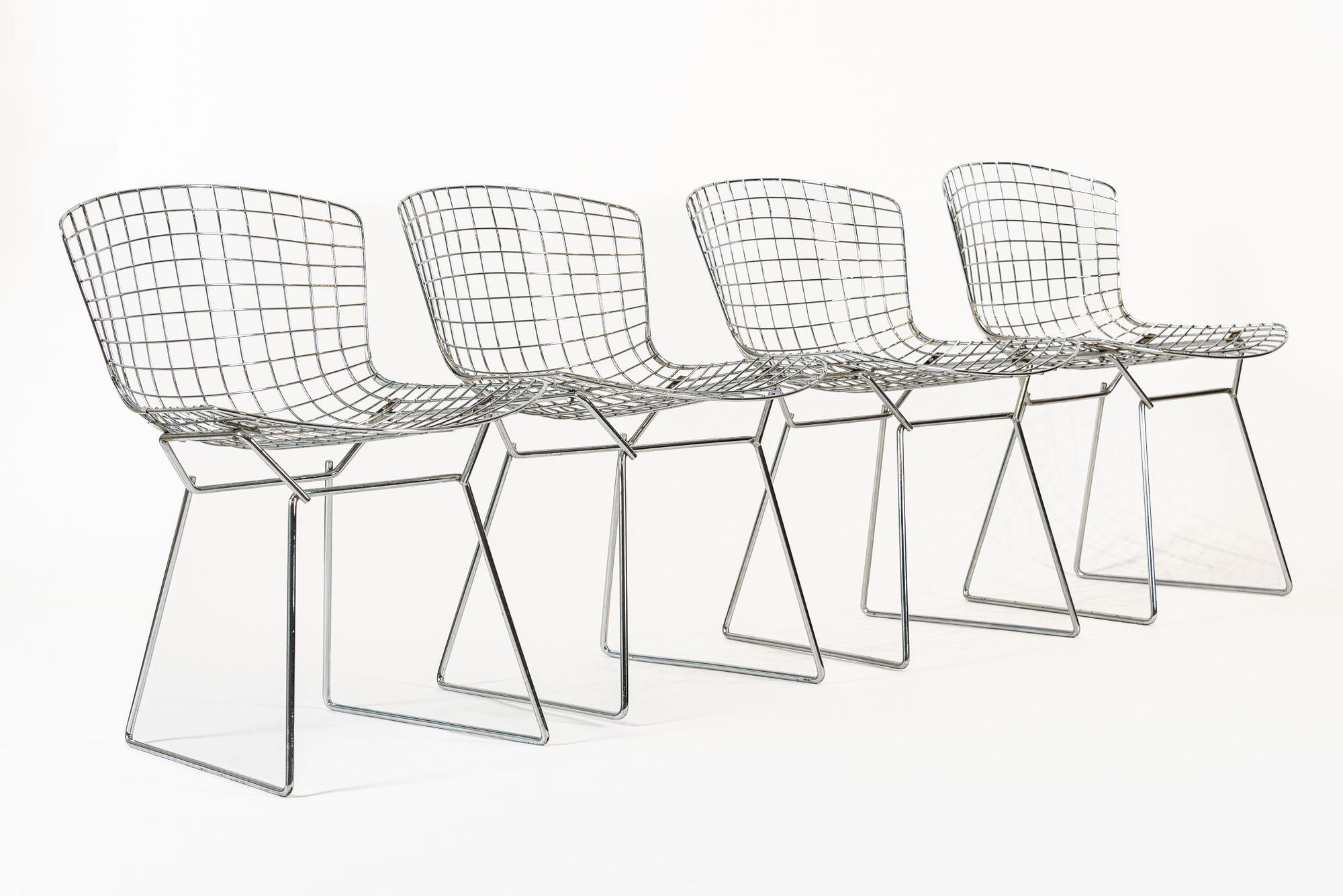 This set of four vintage mid century modern silver wire side dining chairs designed by Harry Bertoia (American, 1915-1978) for Knoll are circa 1970. Originally designed by Bertoia in 1952, the industrial material and sculptural form of the iconic