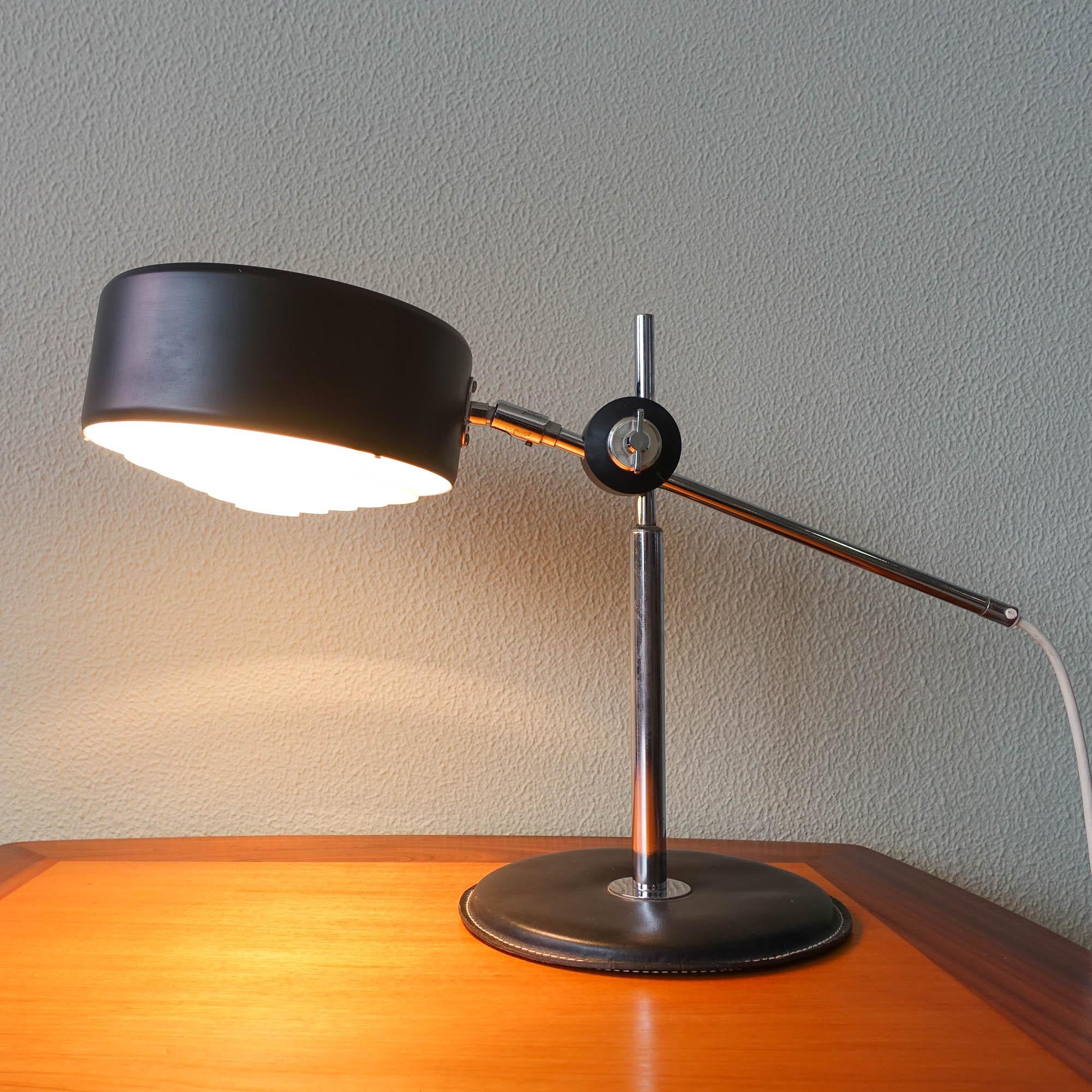 This Simris table lamp was designed by Anders Pehrson for Atelje Lyjktan Sweden in the early 70s. It has a black leather foot and chrome details to the lamp and black shade in metallic. It comes with two standard sockets and has three light settings.