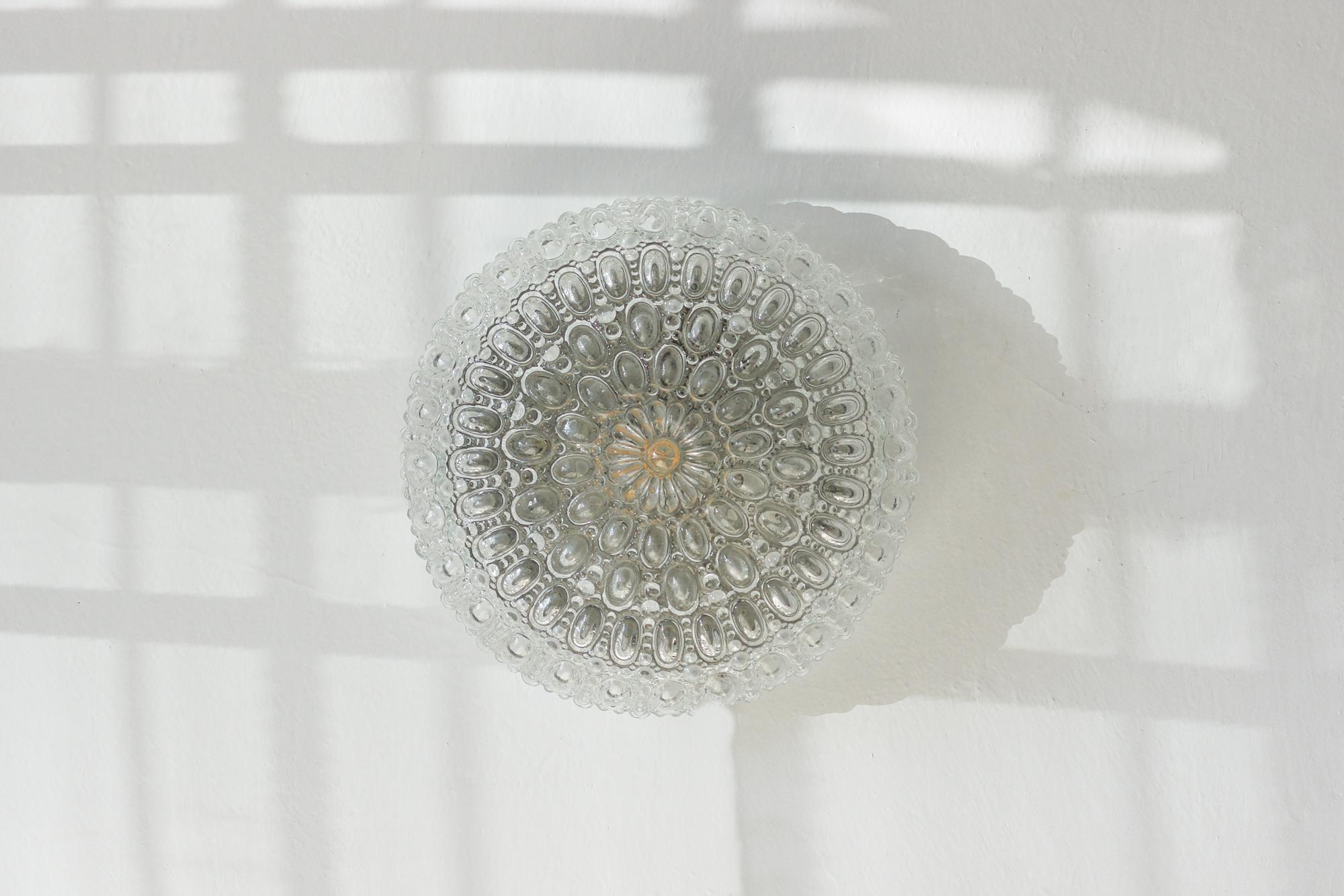 The Sirius ceiling lamp, designed by Helena Tynell for Glashütte Limburg, is an icon of 1960s and 1970s design. The shade is made of thick glass, the surface of which has been formed into a distinctive convex pattern resembling crystal bubbles.