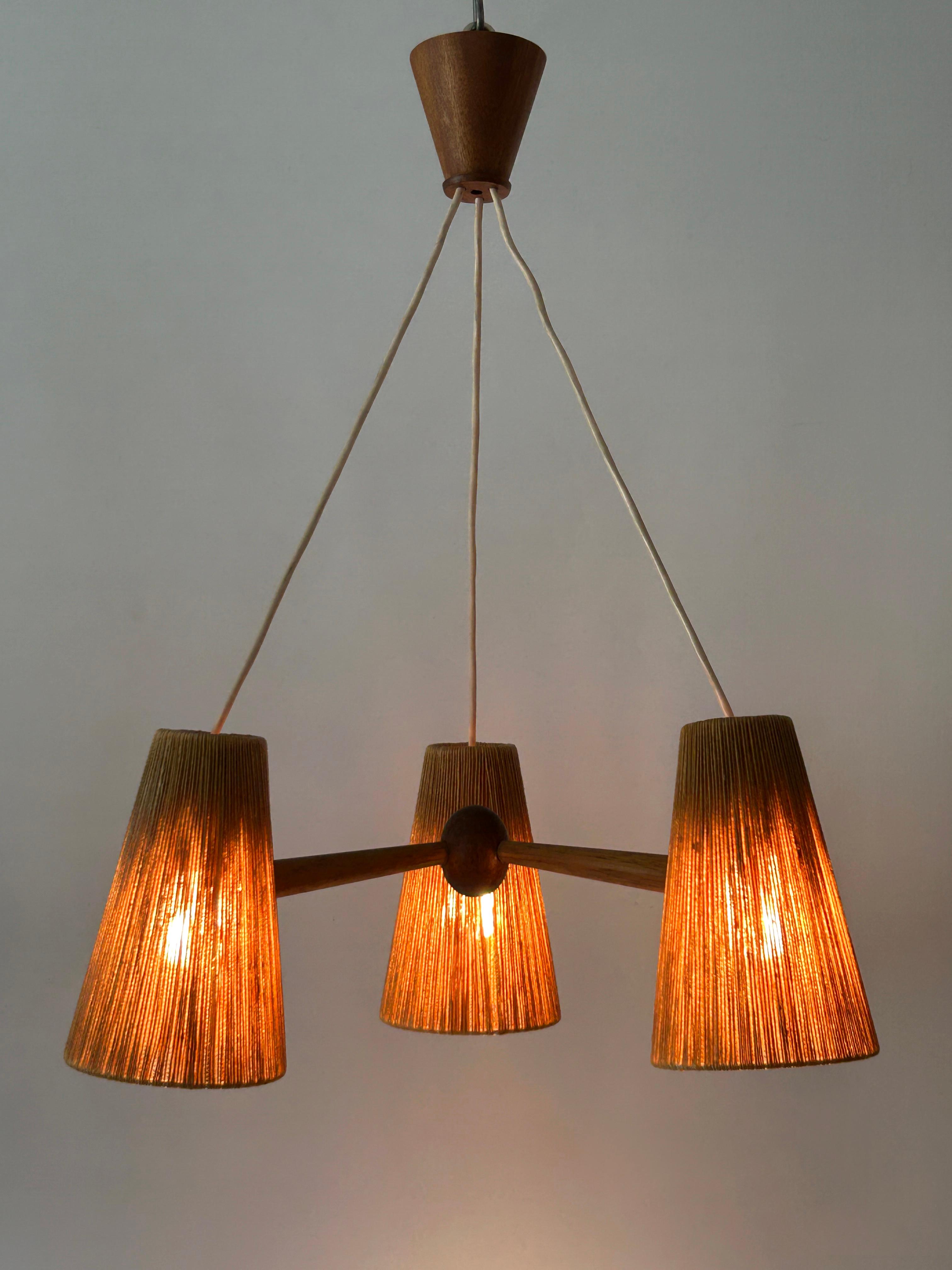 Lustre ou suspension à trois bras, élégant et très décoratif, de style Modern-Decor. Style scandinave. Conçu et fabriqué par Temde Leuchten, Suisse, années 1960.

Réalisé en raphia (sisal) et en bois de teck, le lustre / lampe suspendue nécessite 3