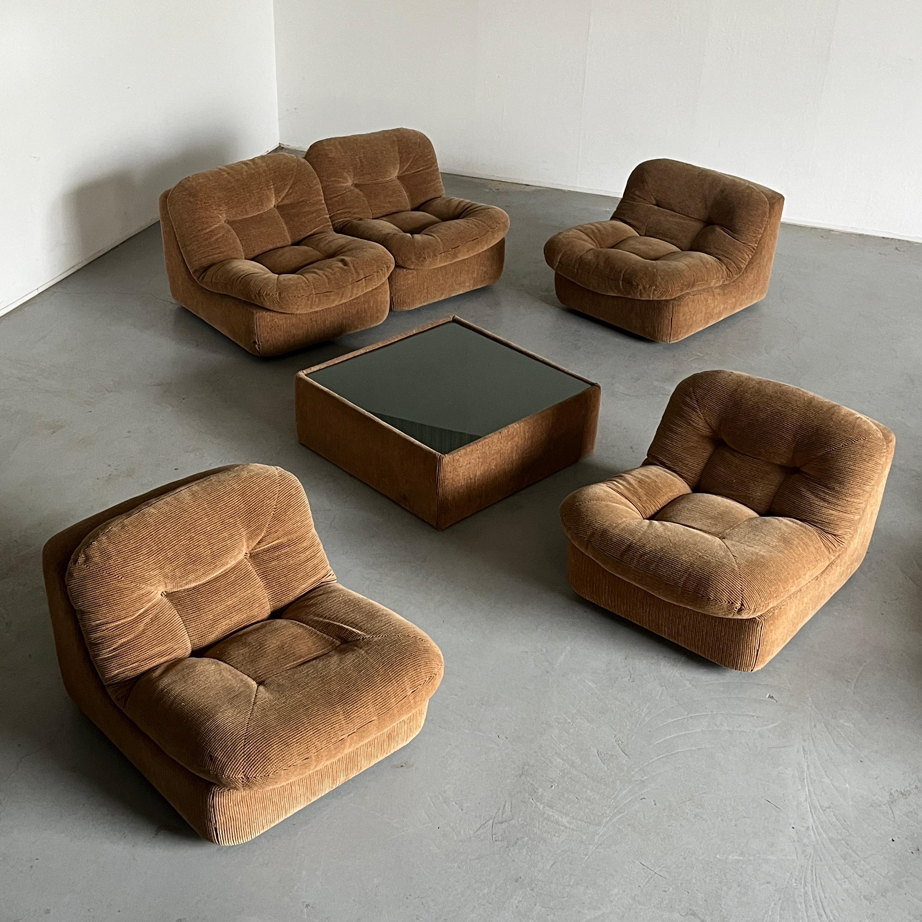 Ensemble de sièges vintage de bon goût composé de cinq modules et d'une table basse en tapisserie beige tuftée. Design italien du milieu du siècle dernier reconnaissable. La table est dotée d'un plateau en verre.
Réminiscence du groupe de sièges