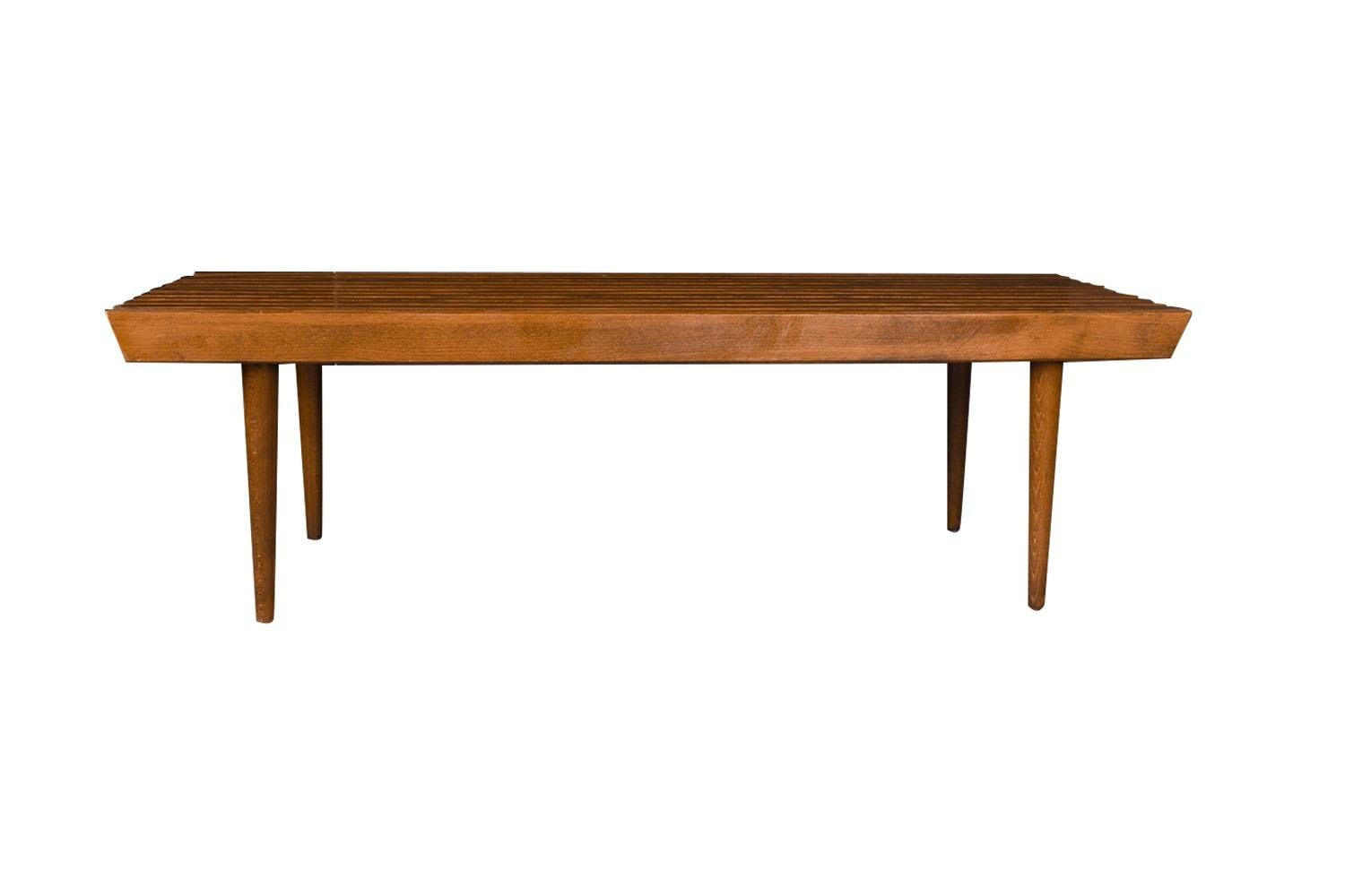 Amazing Mid-Century Modern George Nelson style slat bench coffee table. Classic slat wood coffee table bench. This table is exceptionally well made. Features clean lines and legs that taper down as they reach the floor. An Iconic retro slatted bench