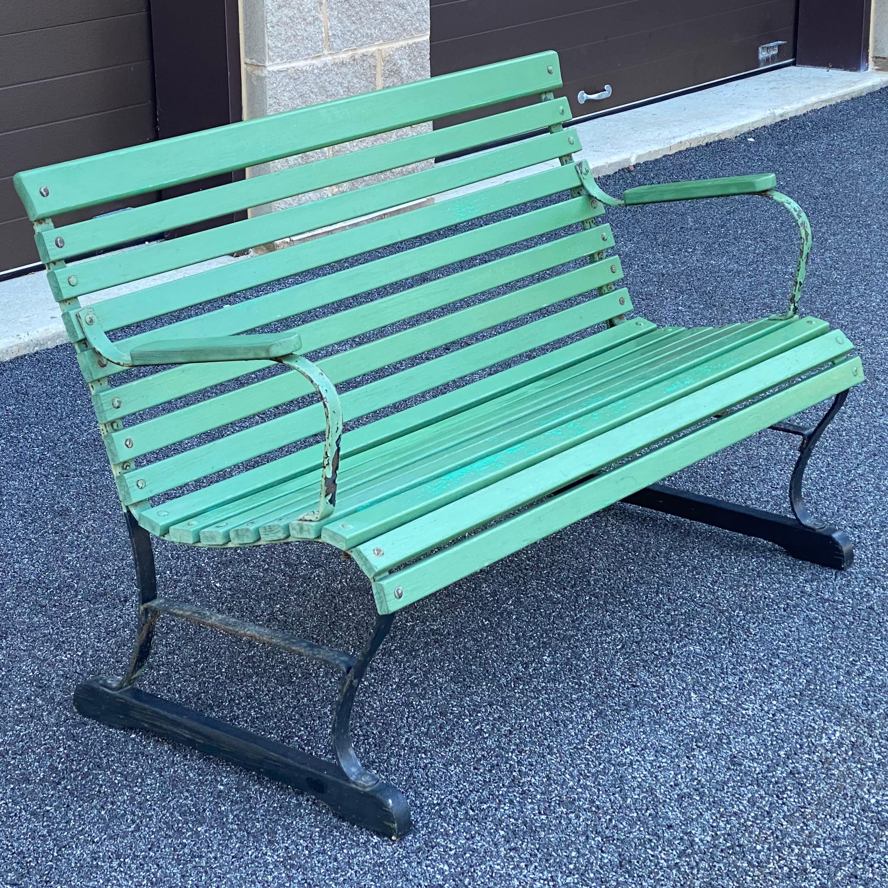Mid century park bench with green painted wood slats over iron frame. Mounted to later wood feet which can easily be removed to accommodate your installation.
Dimensions
48ʺW × 25ʺD × 31ʺH
Additional measurements
42.75” inside width between arms
17”