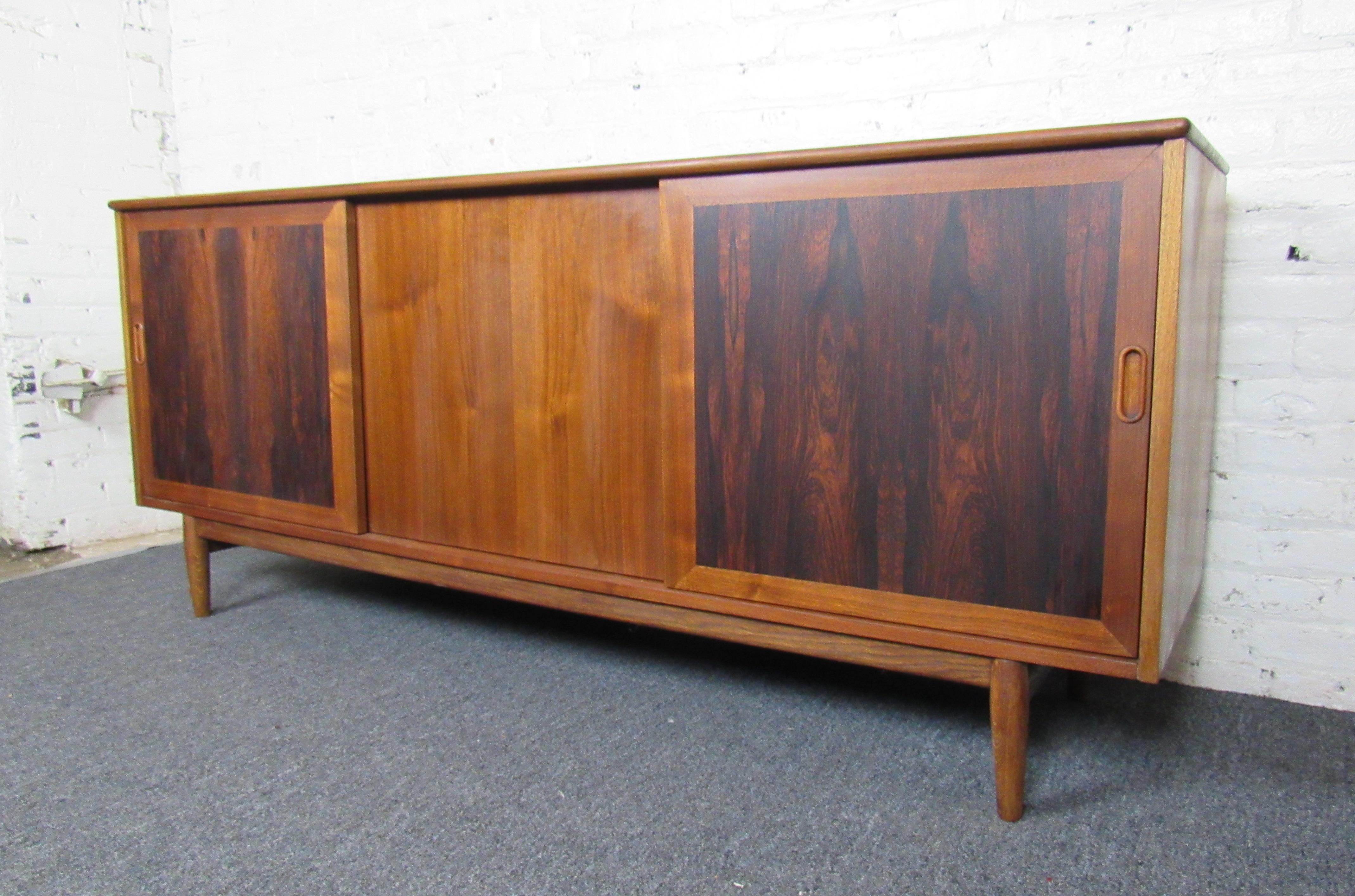 This vintage midcentury credenza combines a rich rosewood grain and vinyl top with beautiful design. Ample storage and easy access drawers make this piece both beautiful and functional. 

Please confirm item location with dealer. (NJ/NY).