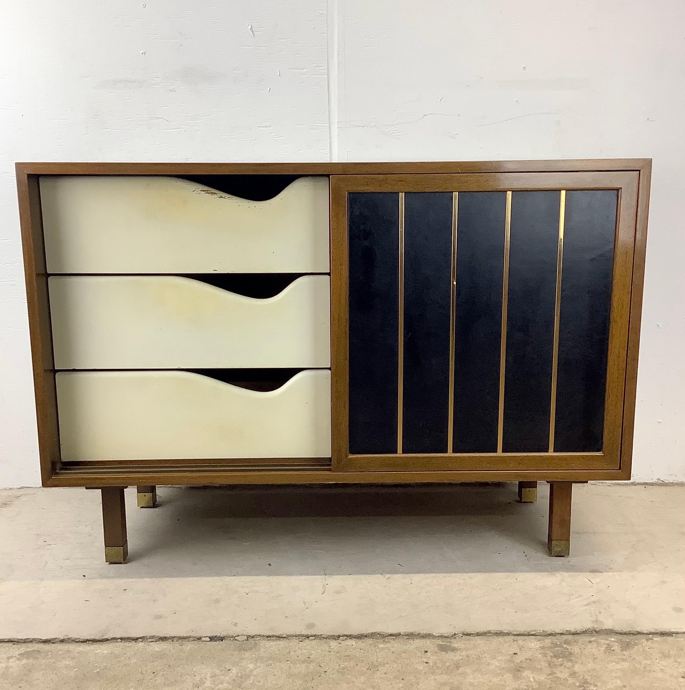 This handsome Mid-Century Modern cabinet from Harvey Probber features fabric wrapped sliding doors concealing side-by-side shelved storage and wide lacquered drawers. The versatile mix of interior storage make this the perfect storage cabinet for