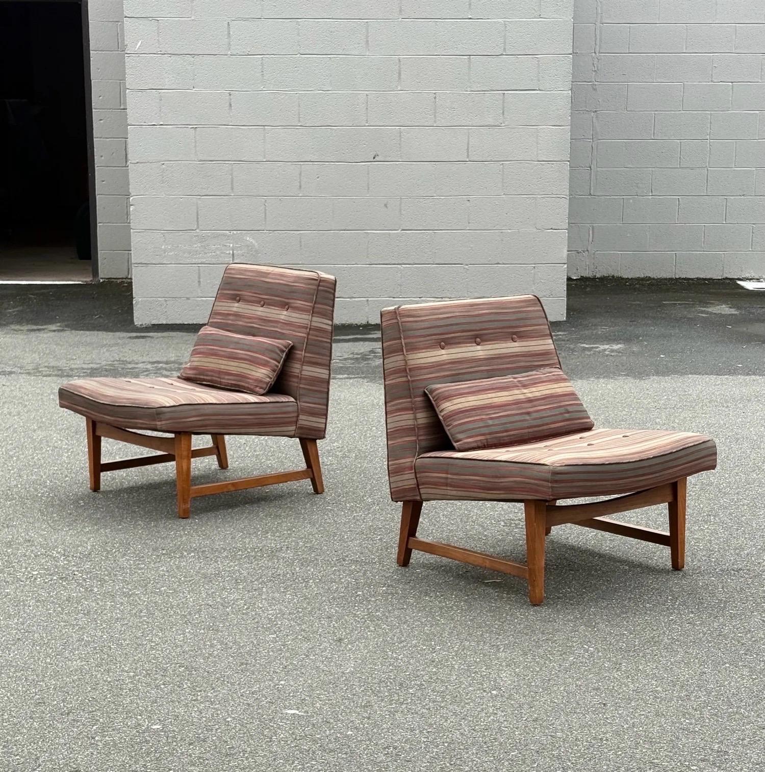 Pareja de sillas slipper de mediados de siglo atribuidas a Edward Wormley para Dunbar. Clásico y aerodinámico con un perfil cuadrado. El perfil lateral resalta las patas y la base del salón de madera de nogal esculpida. El asiento se inclina