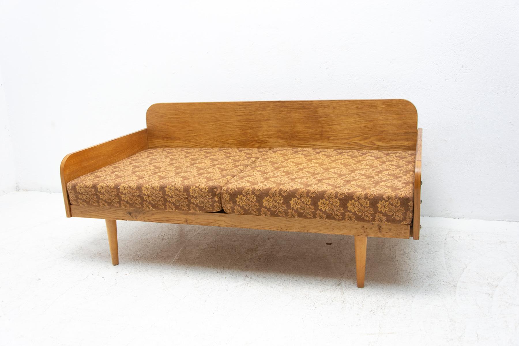 Mid-century small folding sofa from Interiér Praha. It was made in the former Czechoslovakia in the 1960´s. This sofa has wooden structure that is veneered in beech wood. The mattresses are rather soft but comfortable. Overall in good Vintage