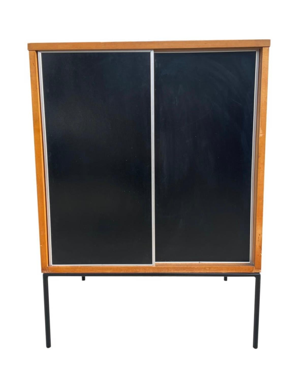 Beautiful midcentury small cabinet by Paul McCobb circa 1950 Planner Group #1512 has 1 fixed shelf - solid maple construction has a blonde lacquer finish. Has very rare all original black & white aluminum trim sliding front doors sits on an iron