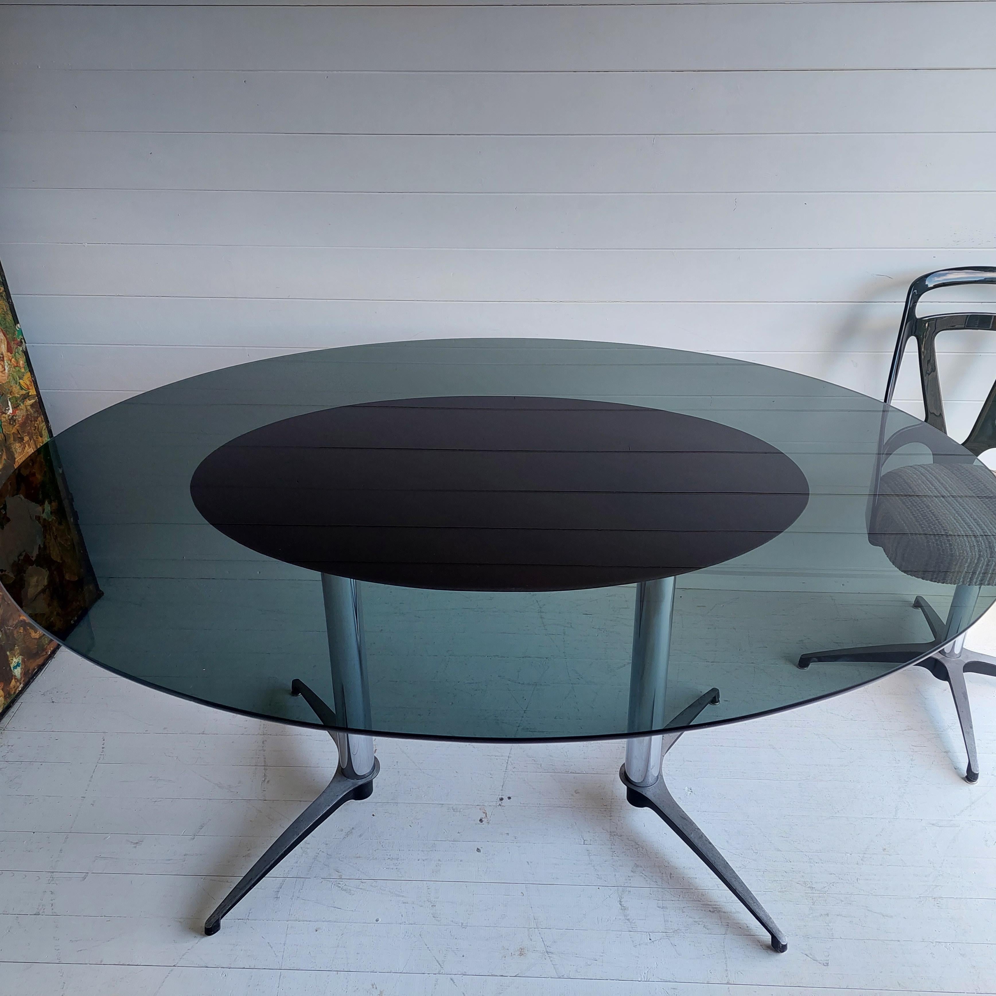 Retro Chromcraft USA Grafton Atomic Esstisch.
Eine fantastische und äußerst stilvolle Esszimmereinrichtung von 1972.

Ein großer ovaler Esszimmertisch mit einer Platte aus Rauchglas und Beinen aus Aluminiumguss.

Dieser Tisch ist in einem für sein