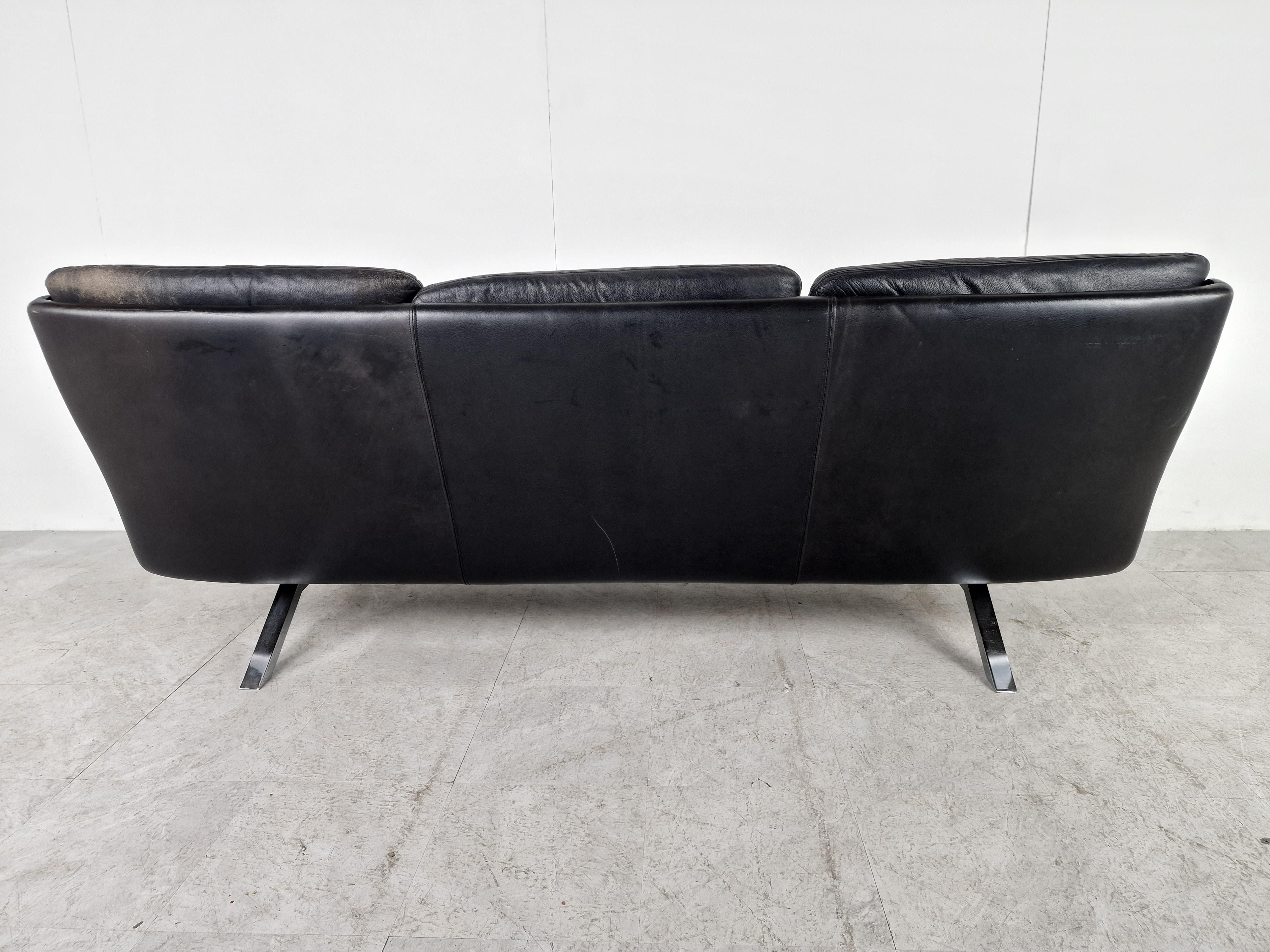 Mid-century three seater sofa designed by Carl Straub in black leather and teak.

Beautifully shaped metal base.

Good overall condition with normal age related wear. No holes or rips.

1960s - Germany

Height: 78cm/30.64
