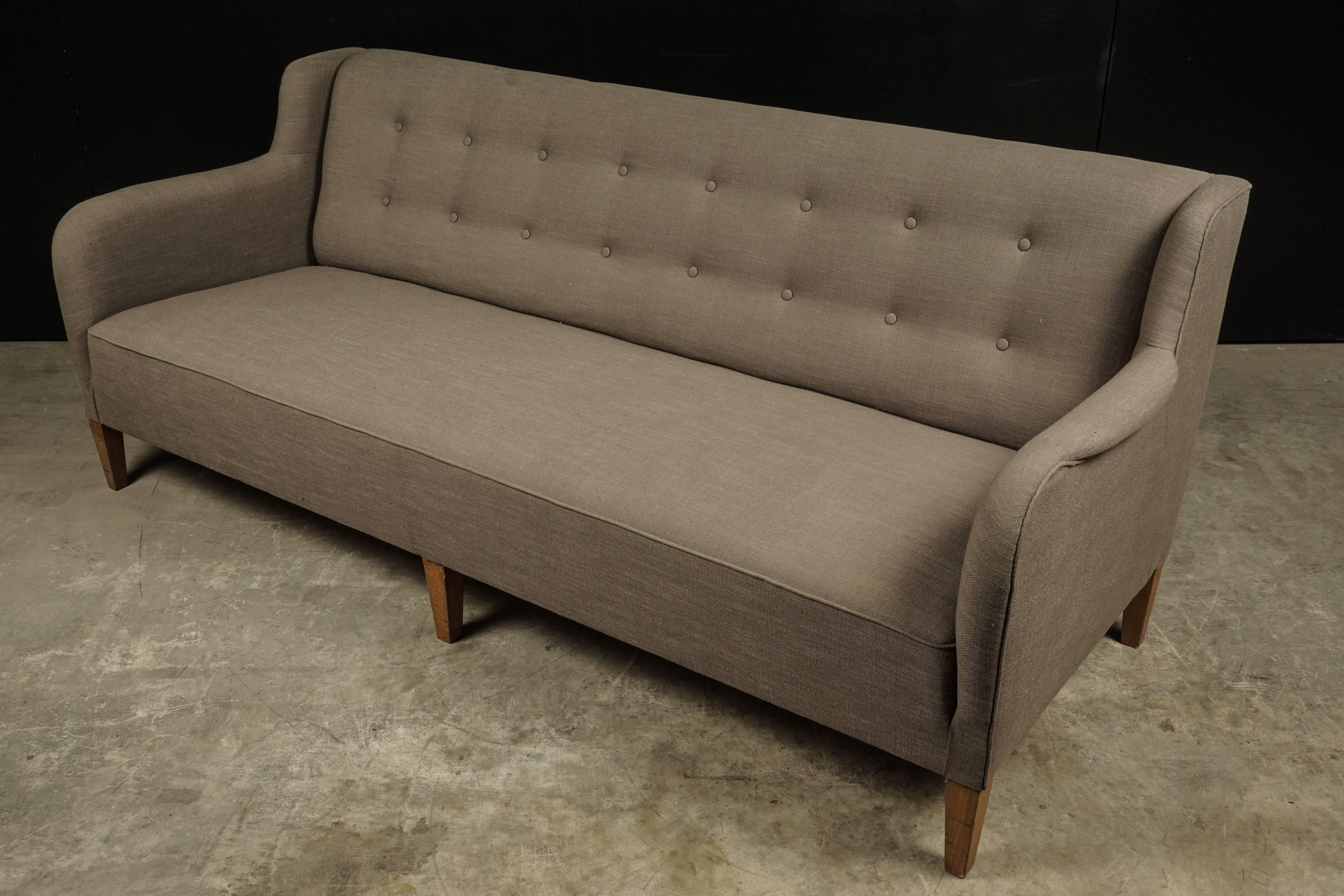 Midcentury sofa from Denmark in the manner of Flemming Lassen, circa 1980. Upholstered in grey linen with solid birch feet.
Measures: Seat height 15