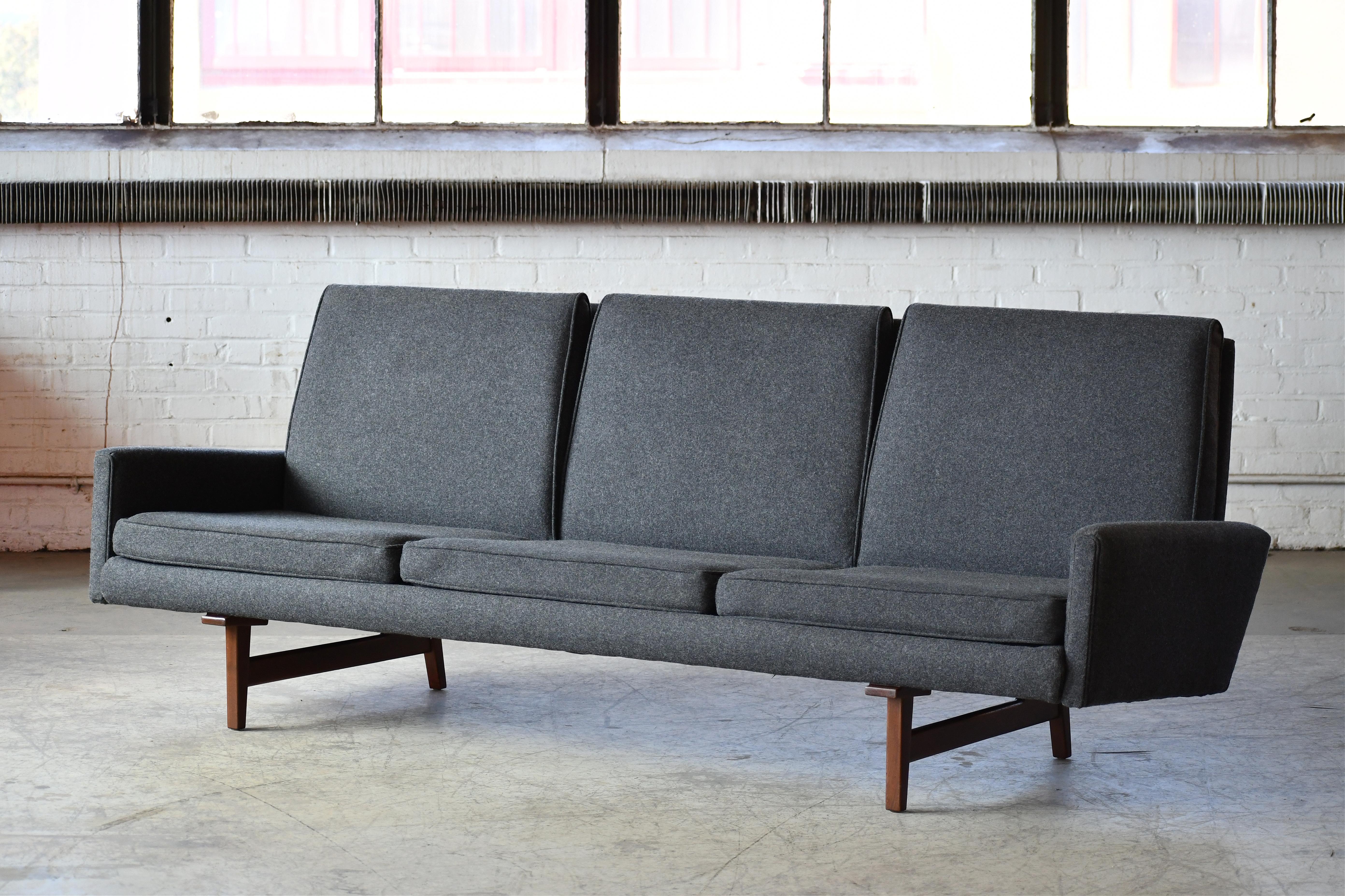 Classic mid-century three-seat sofa by one of the Grand Masters of the era, Jens Risom. Newly upholstered an a charcoal grey wool. Low profile cushions add to the sleek elegant look. Very high design build quality and overall in excellent condition.