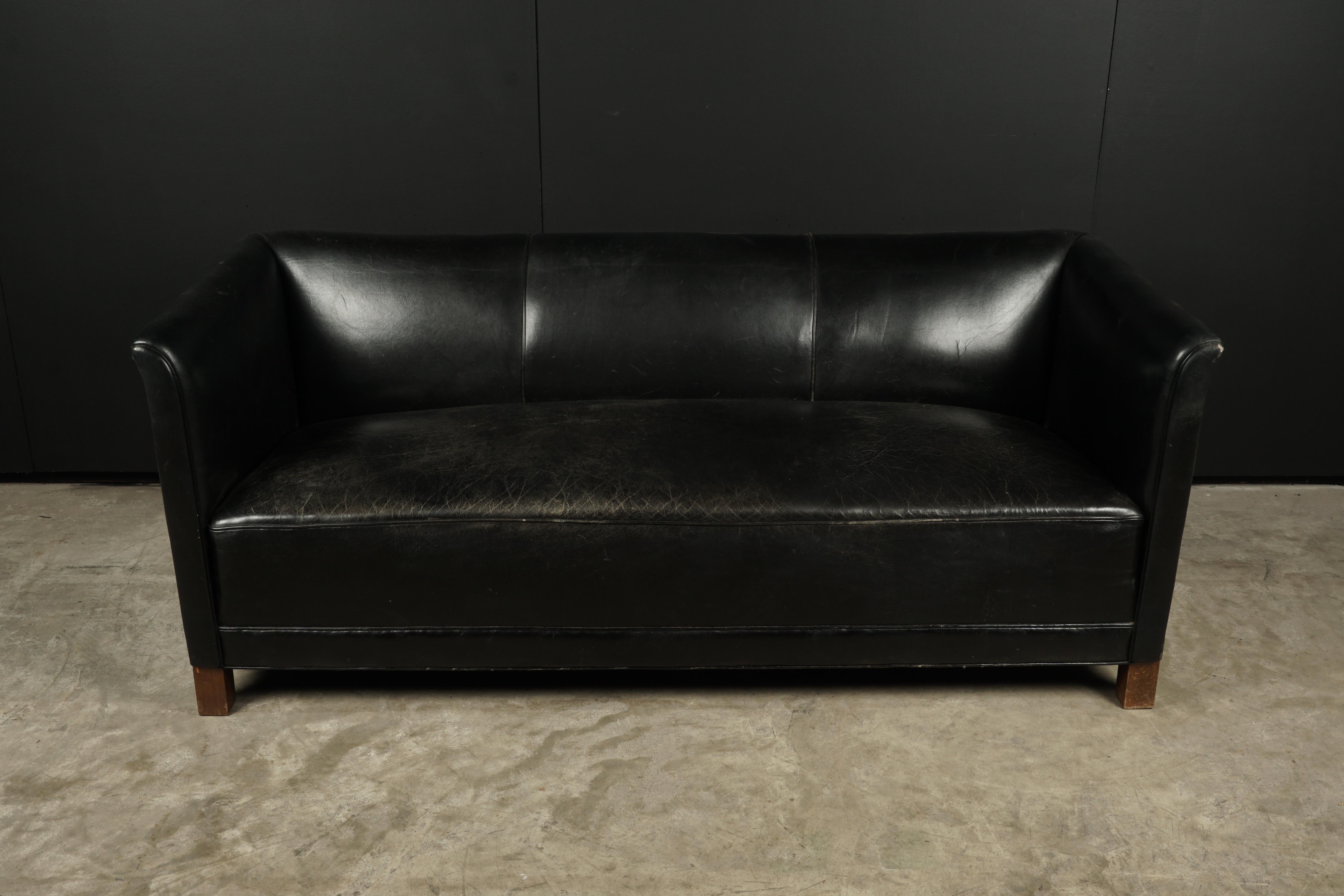 Vintage leather sofa manufactured by Fritz Hansen, Denmark, circa 1960. Original black leather upholstery with legs of beech.