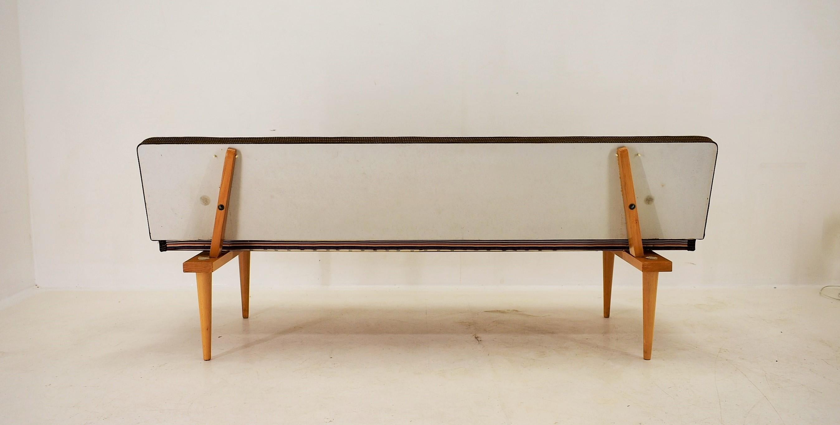 Iconic model by Interier Praha, produced in the 1960's. When unfolded, the bed measures 85 cm in width. 
Cleaned.