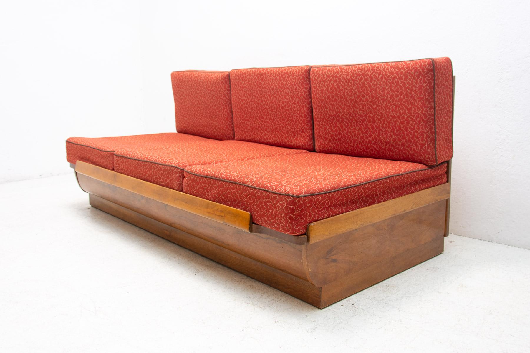 Mid century sofabed designed by Jindrich Halabala for UP Zavody. It was made in the former Czechoslovakia in the 1950´s. This sofa has a walnut veneered wooden structure and storage space for bedding. It´s adjustable for sleeping. The sofa is in