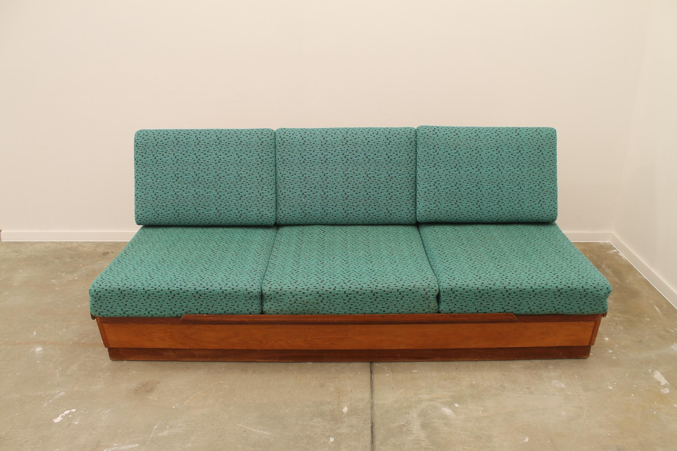 midcentury sofabed designed by Jindrich Halabala for UP Zavody. It was made in the former Czechoslovakia in the 1950´s. This sofa has a walnut veneered wooden structure and storage space for bedding. It´s adjustable for sleeping. The sofa is in good