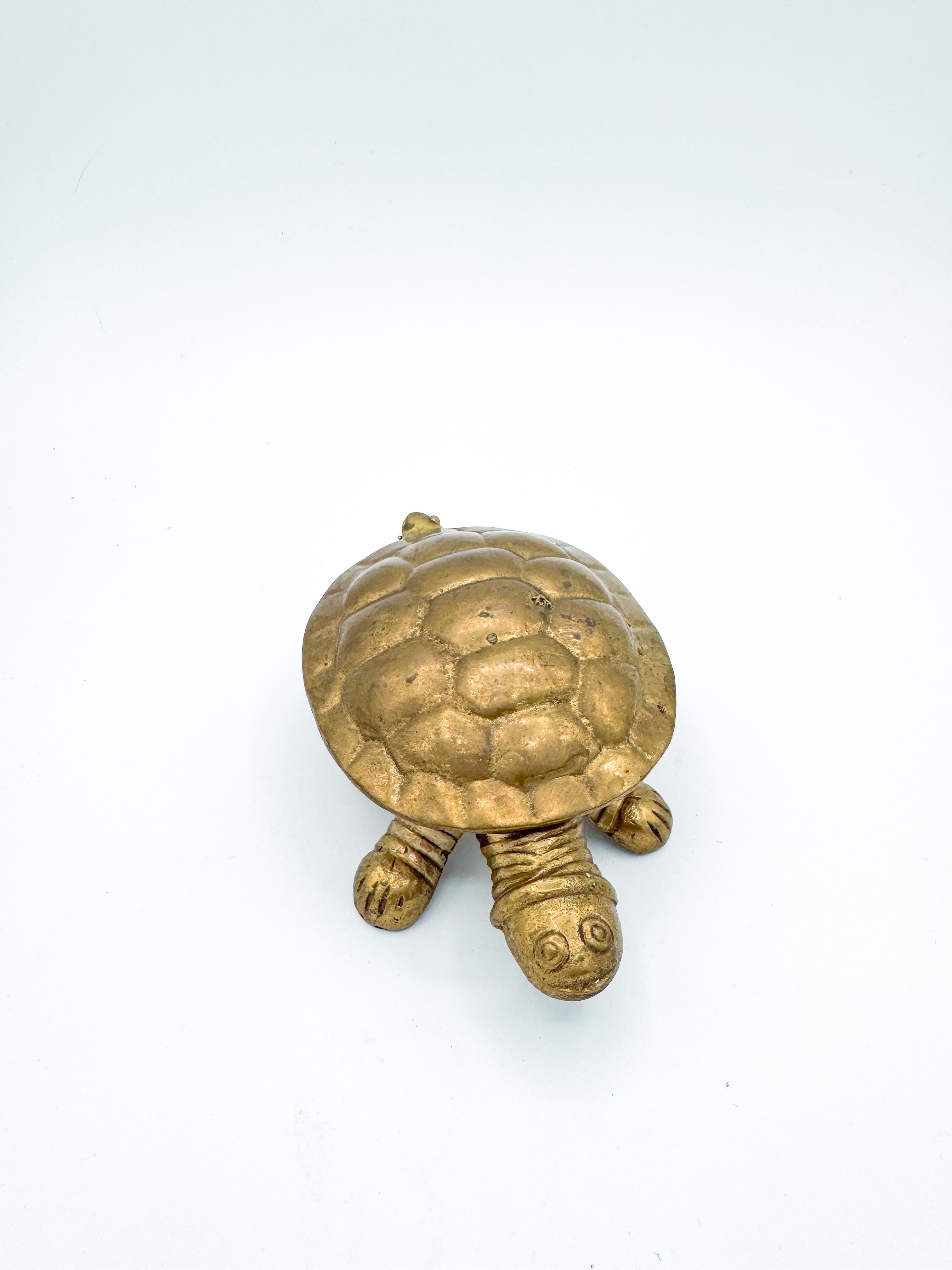 Cet adorable cendrier tortue vintage est fabriqué en laiton massif et comporte une coque à charnière qui s'ouvre pour révéler un cendrier fonctionnel peu profond à l'intérieur. Fantaisiste et élégante, elle constitue un ajout charmant aux vignettes